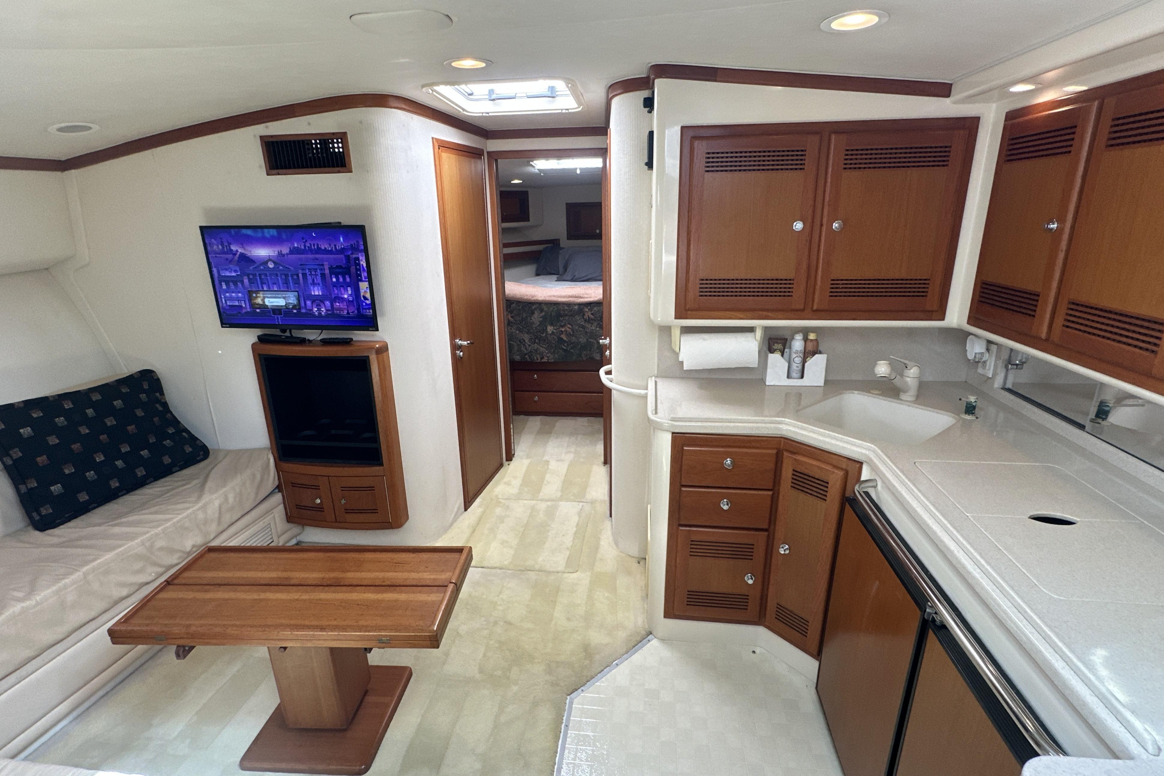 Interior of 2000 Cabo 45 Express yacht with kitchen, seating, and TV.