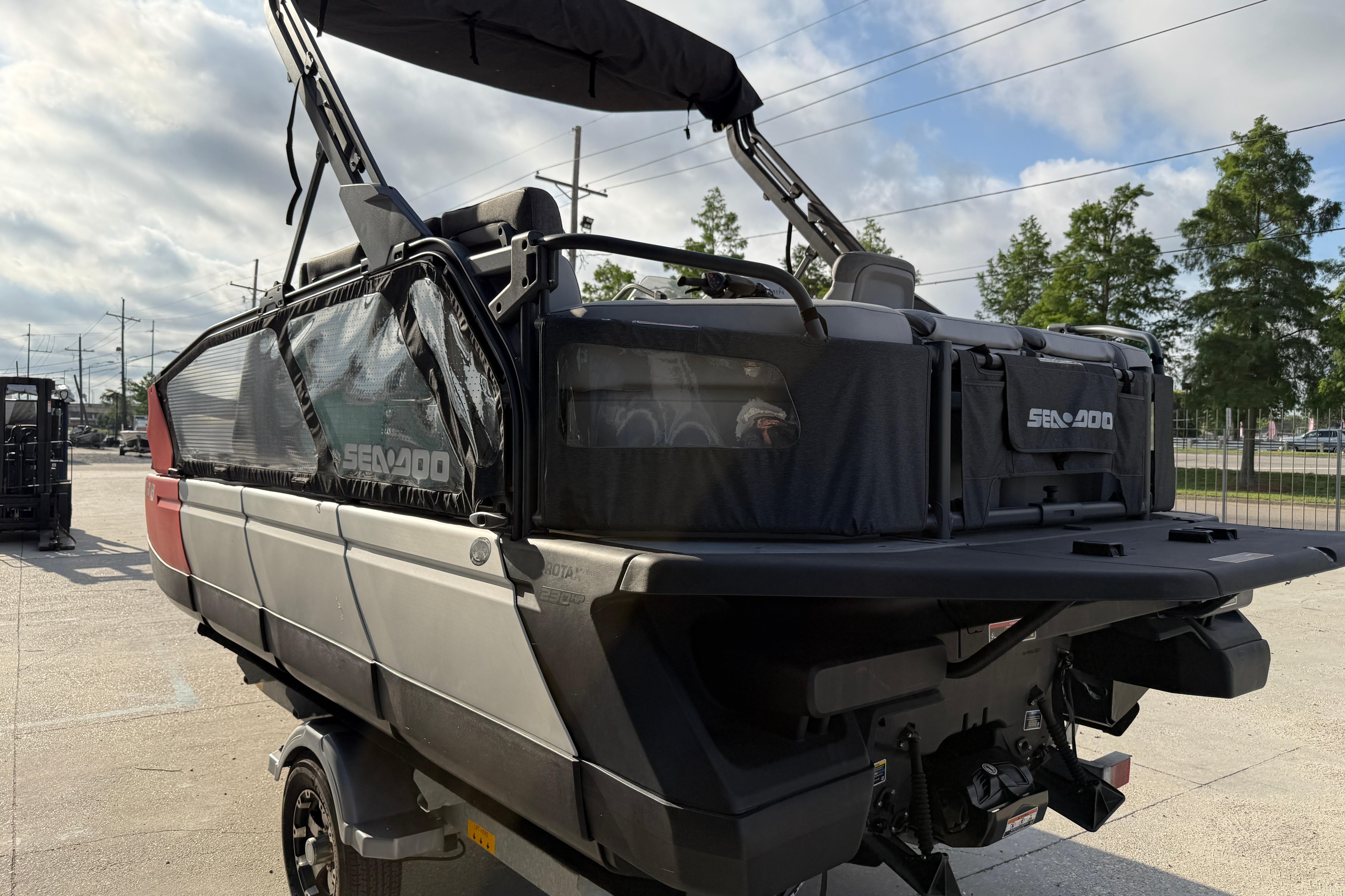 2023 Sea-Doo Switch Sport 18 pontoon boat with canopy, parked outdoors.