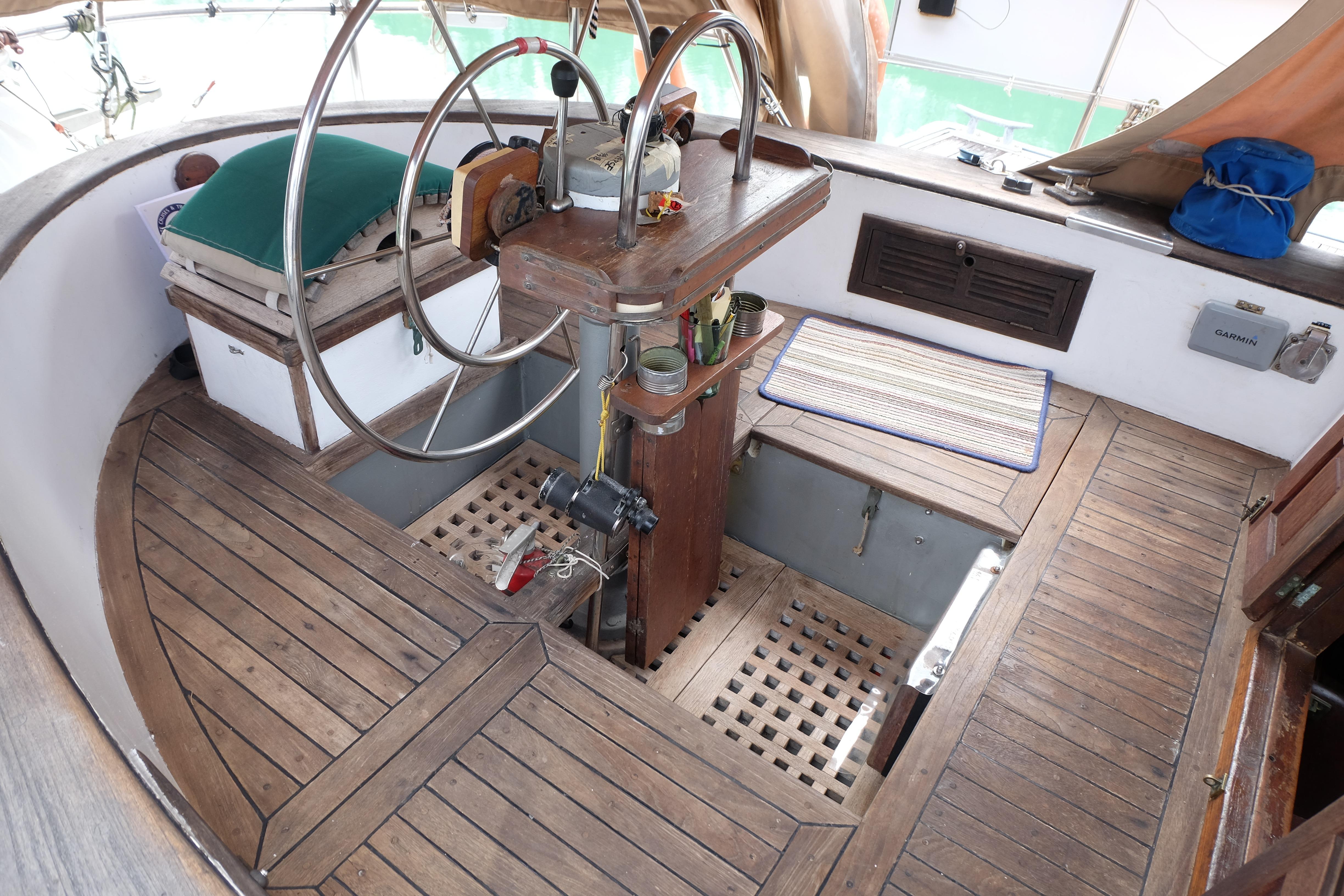 Cockpit of 1979 Westwind 35 sailboat with wooden flooring and steering wheel.