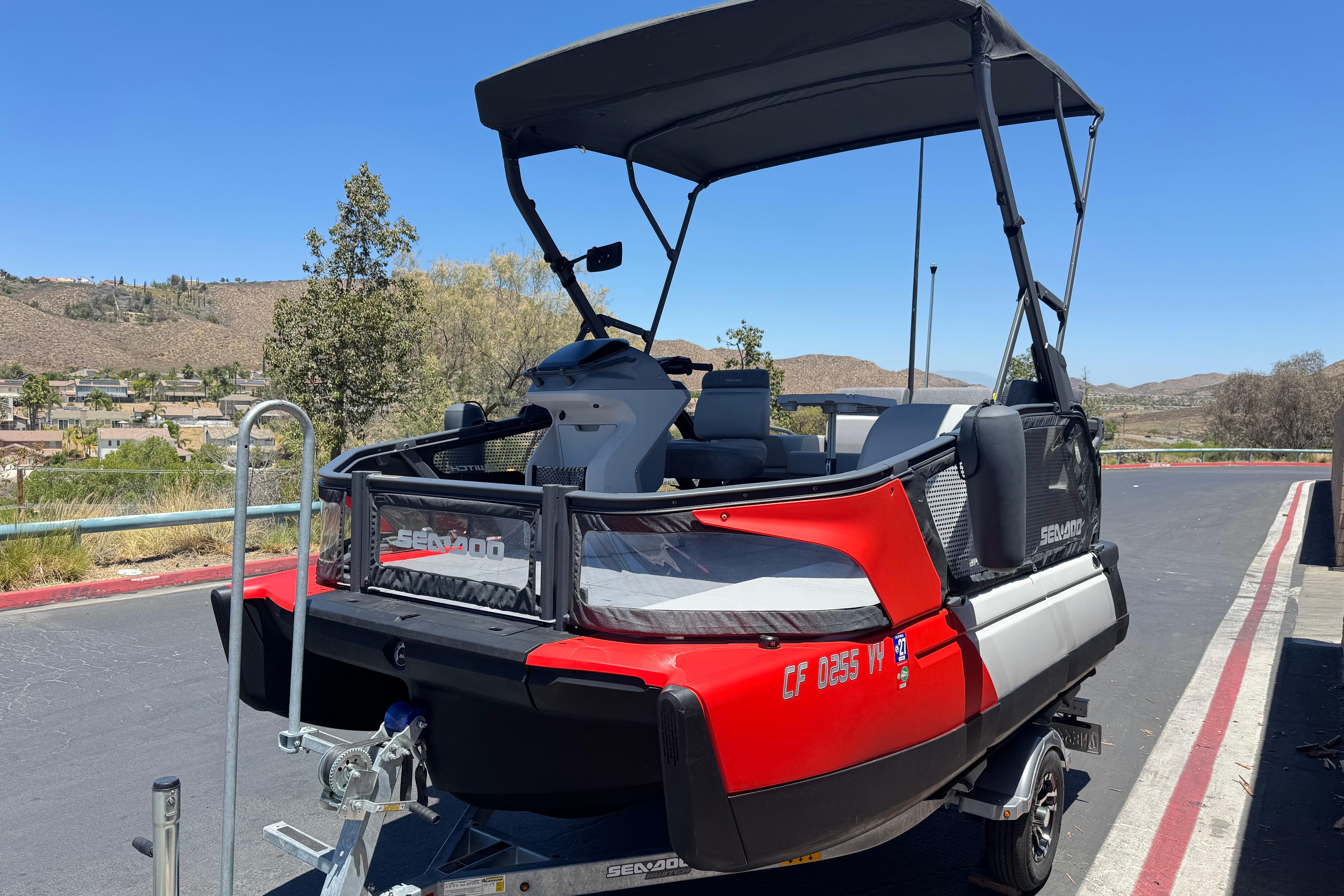 2024 Sea-Doo Switch Compact on trailer, red and black design, parked outdoors.