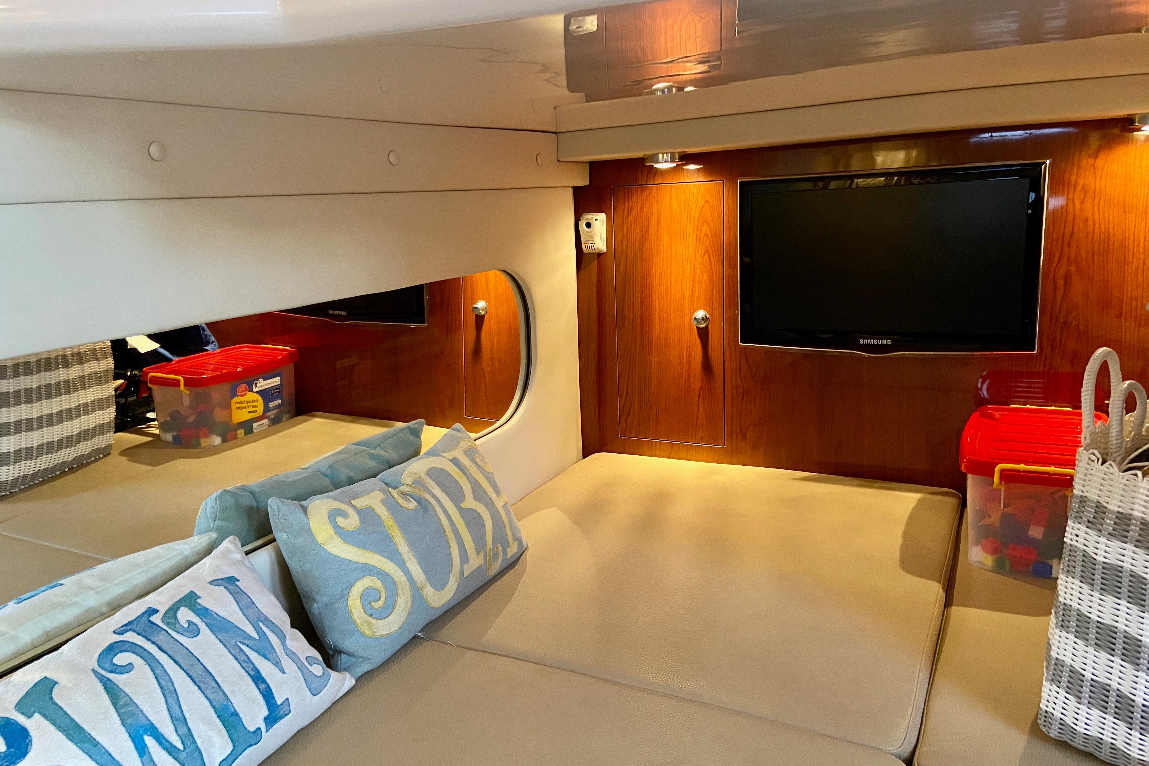 Cozy interior of 2012 Regal 35 Express Cruiser with TV and decorative pillows.