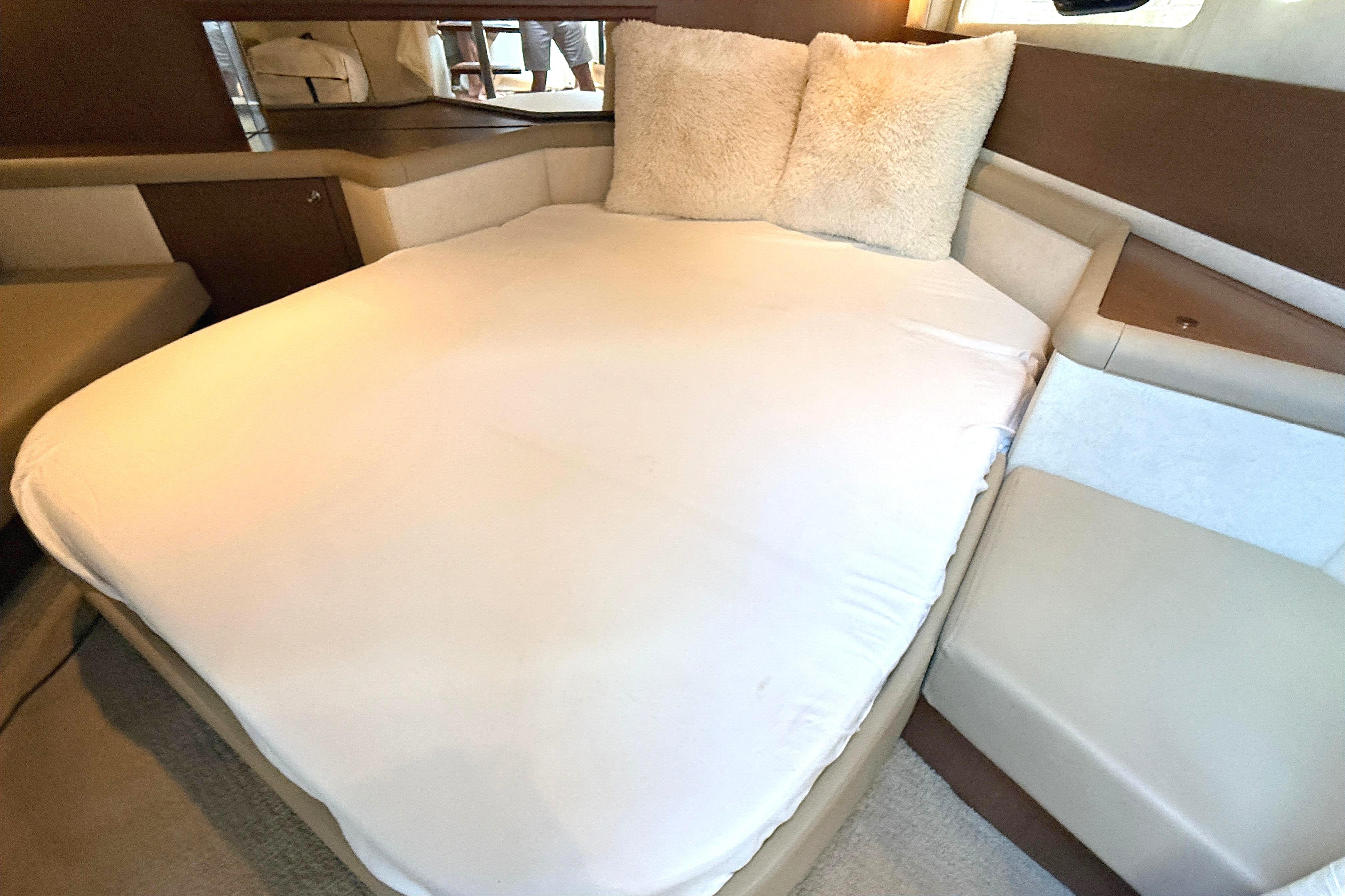 Cozy cabin interior of 2013 Sea Ray 370 Venture with plush bedding.