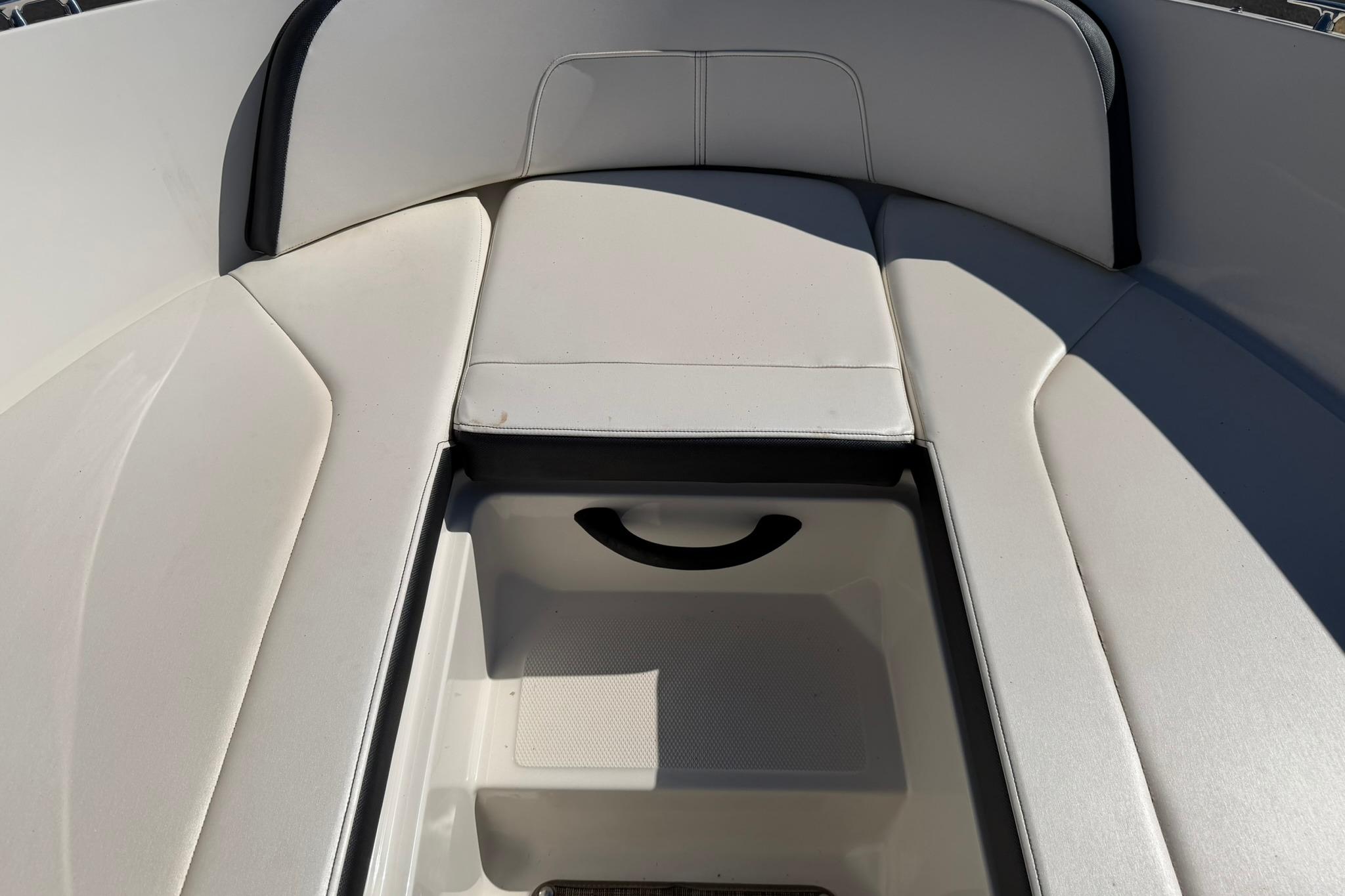 2016 Sea Ray SPX 210 boat interior with cushioned seating and storage compartment.