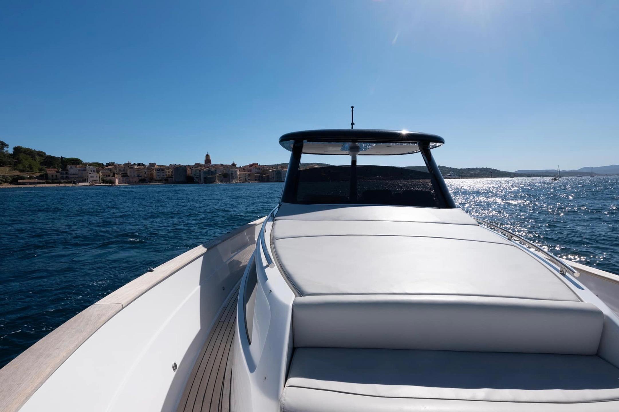 2023 Apreamare GOZZO 35 yacht cruising on a sunny day near coastal town.