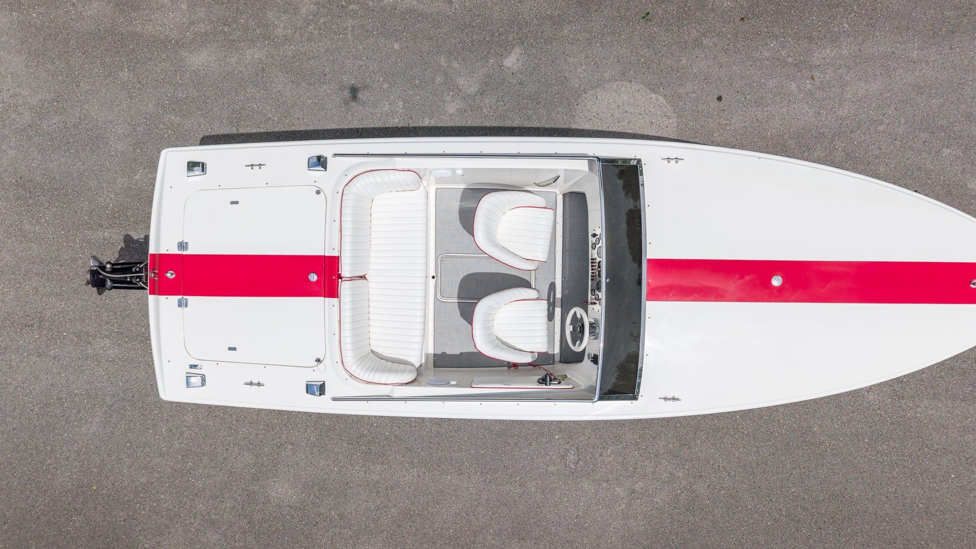 Aerial view of a white 1995 Donzi Classic with a red stripe, on a gray surface.