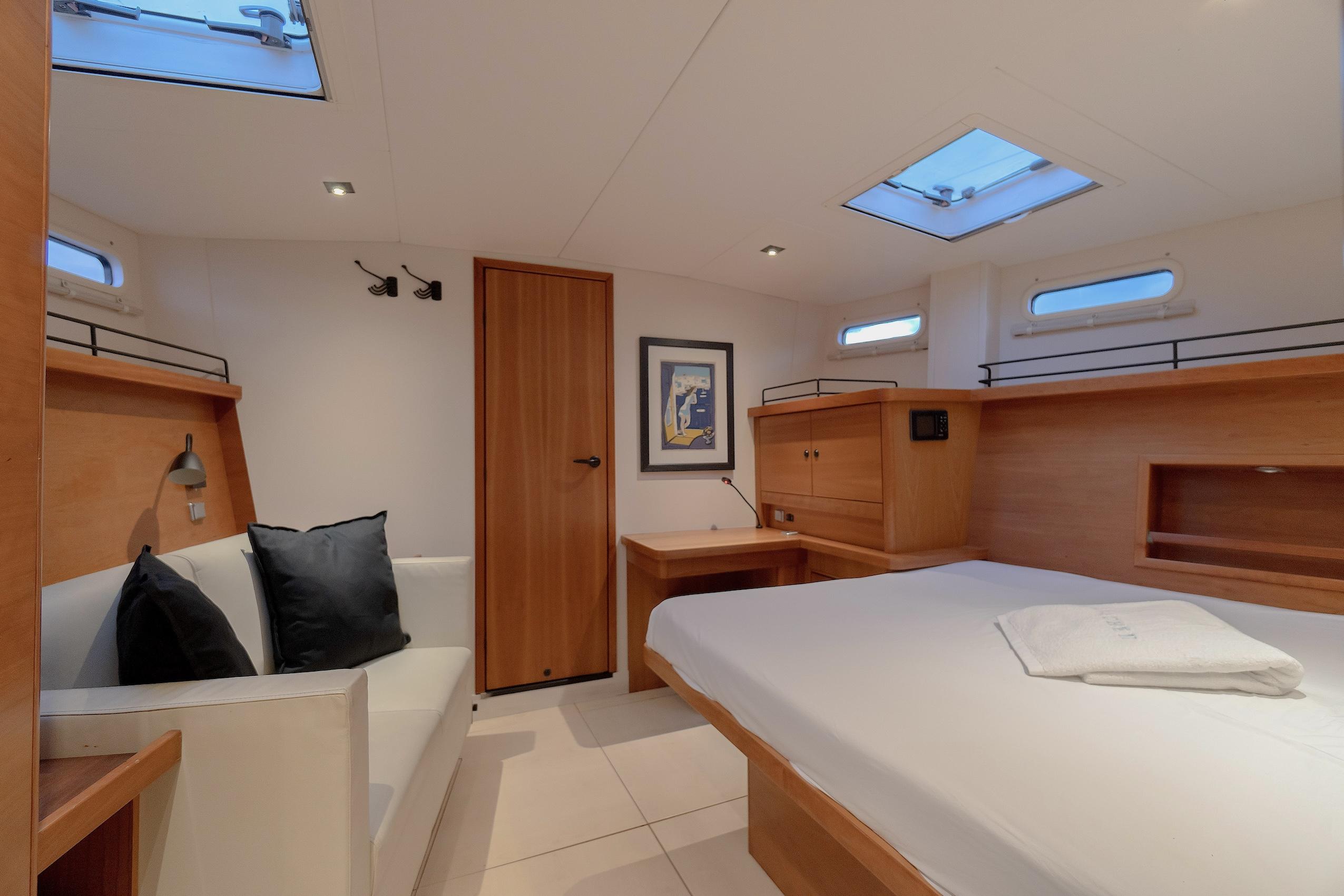 Luxurious cabin interior of 2009 Hanse 630e yacht with modern furnishings and skylights.