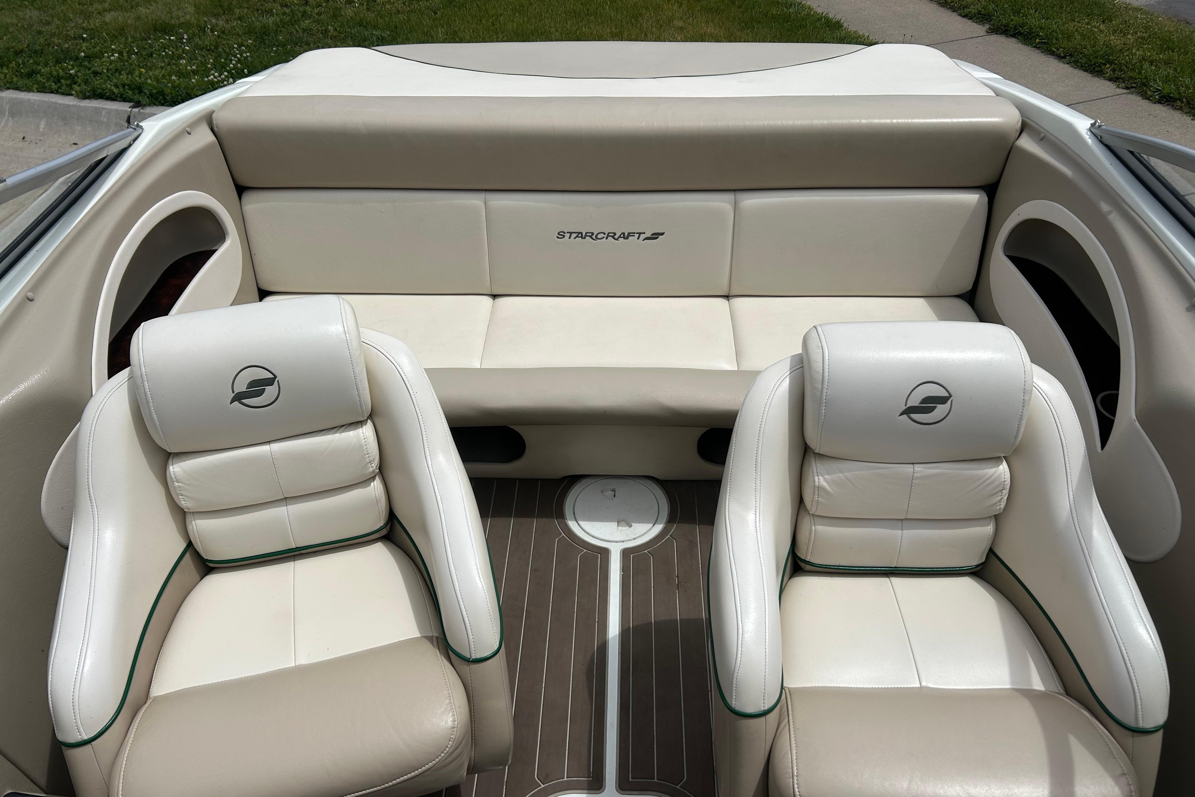 Interior of a 2000 Starcraft 1810 boat with beige seating and logo.