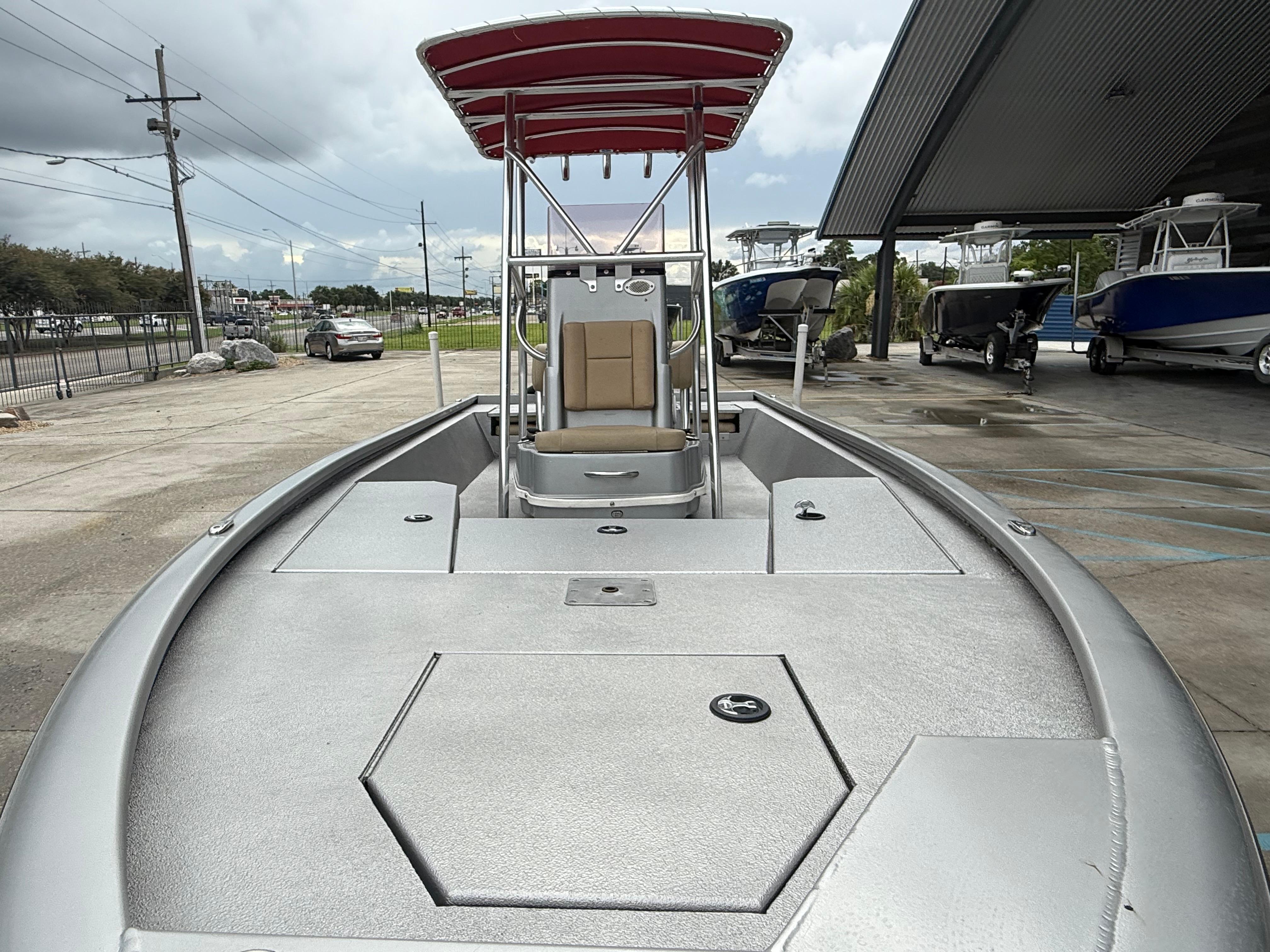 2020 Avid 23 FS Platinum boat with red canopy, docked outdoors.