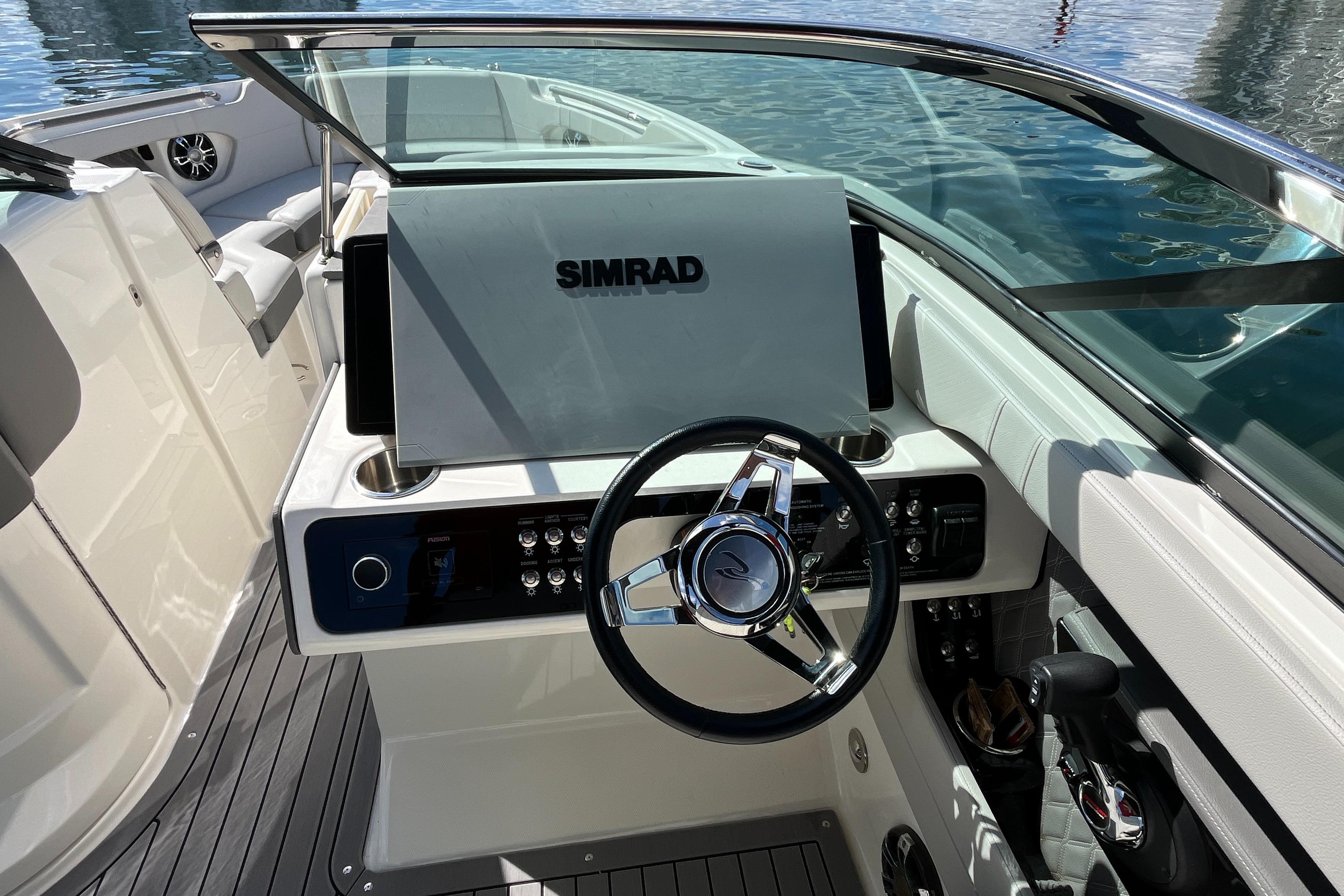2021 Sea Ray SLX 280 boat helm with Simrad display and sleek steering wheel.