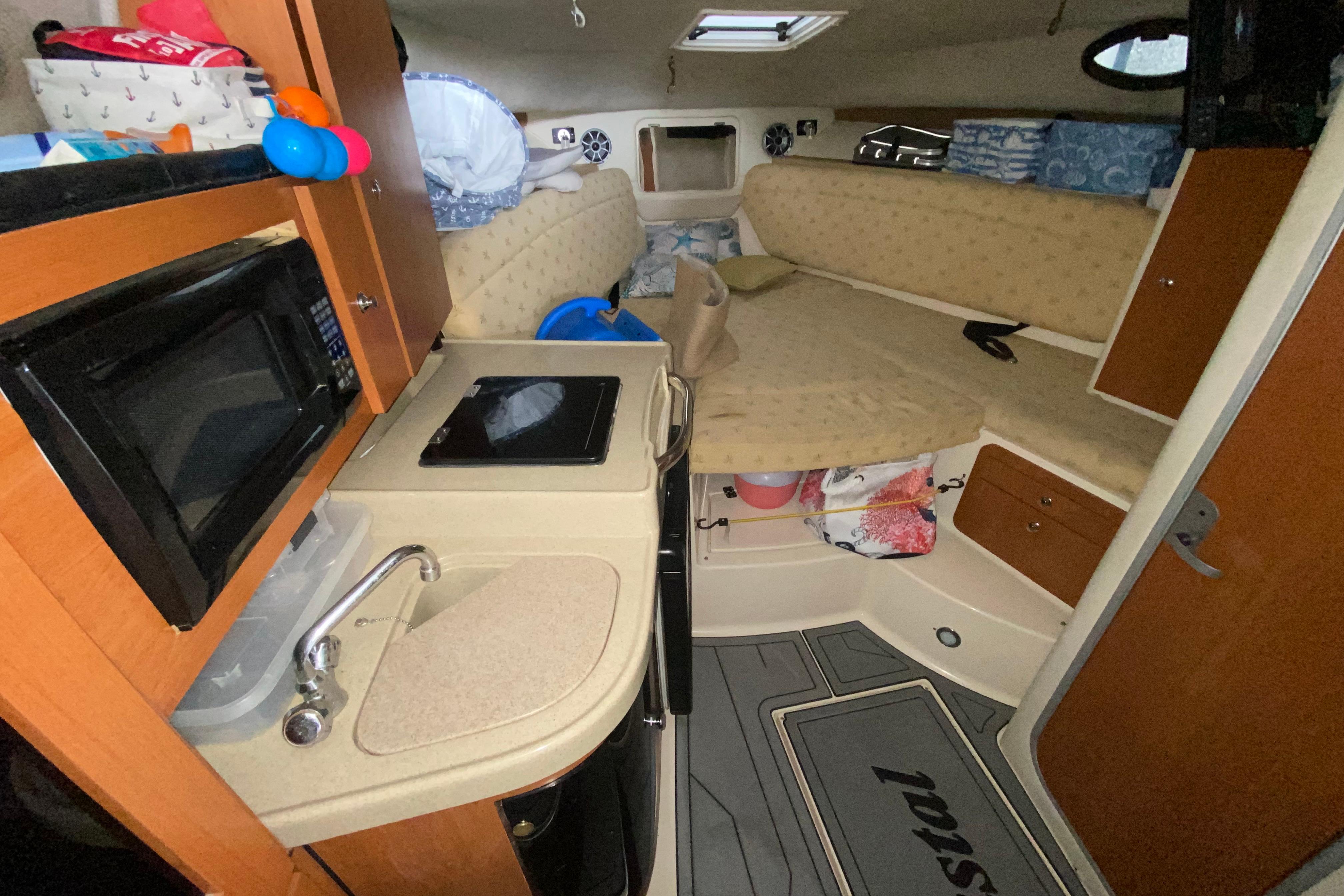 Interior of 2005 Wellcraft 290 Coastal boat with kitchenette and seating area.