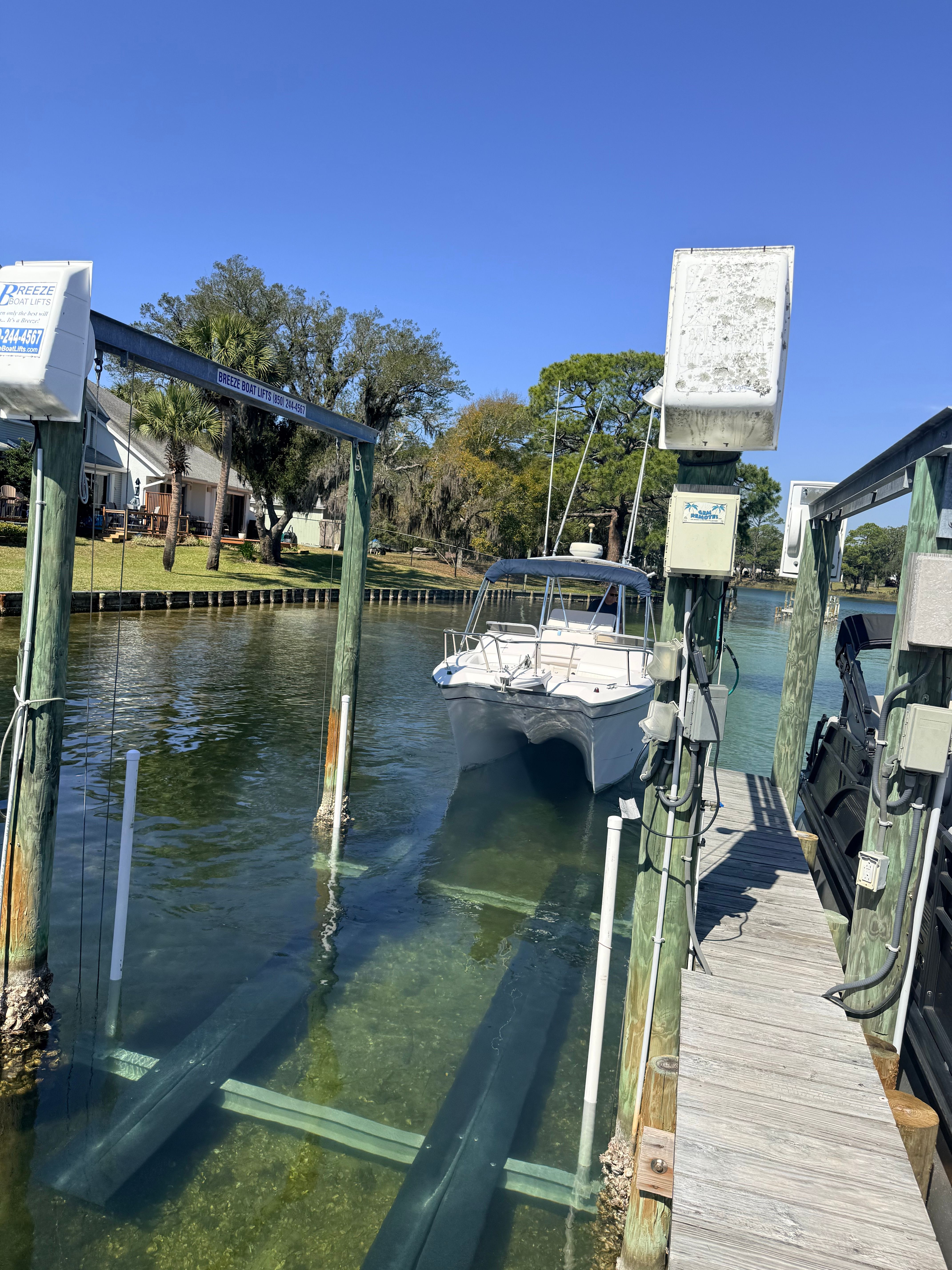 Grady-White X26 Tigercat 2000 on boat lift by the water.