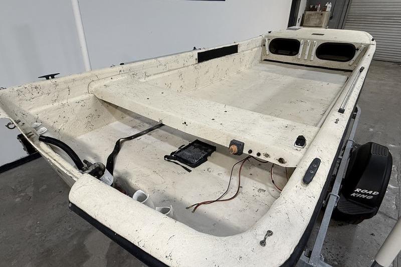 1998 Carolina Skiff 1965 V boat interior, showing worn white deck and wiring.