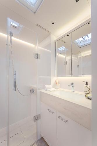 Luxurious bathroom in 2025 Lagoon SIXTY 5 yacht with modern fixtures and skylight.