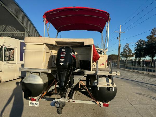 2005 Starcraft 22 Sport pontoon boat with red canopy and outboard motor.