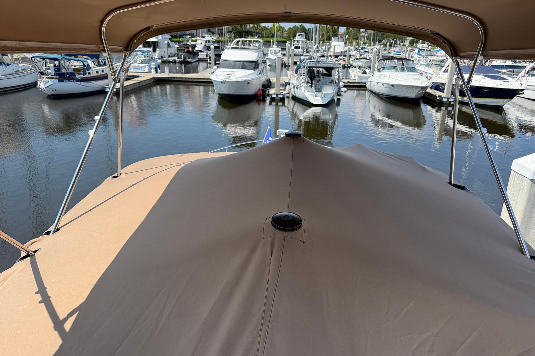 Covered deck of 2013 Carver C34 yacht in marina, surrounded by boats.