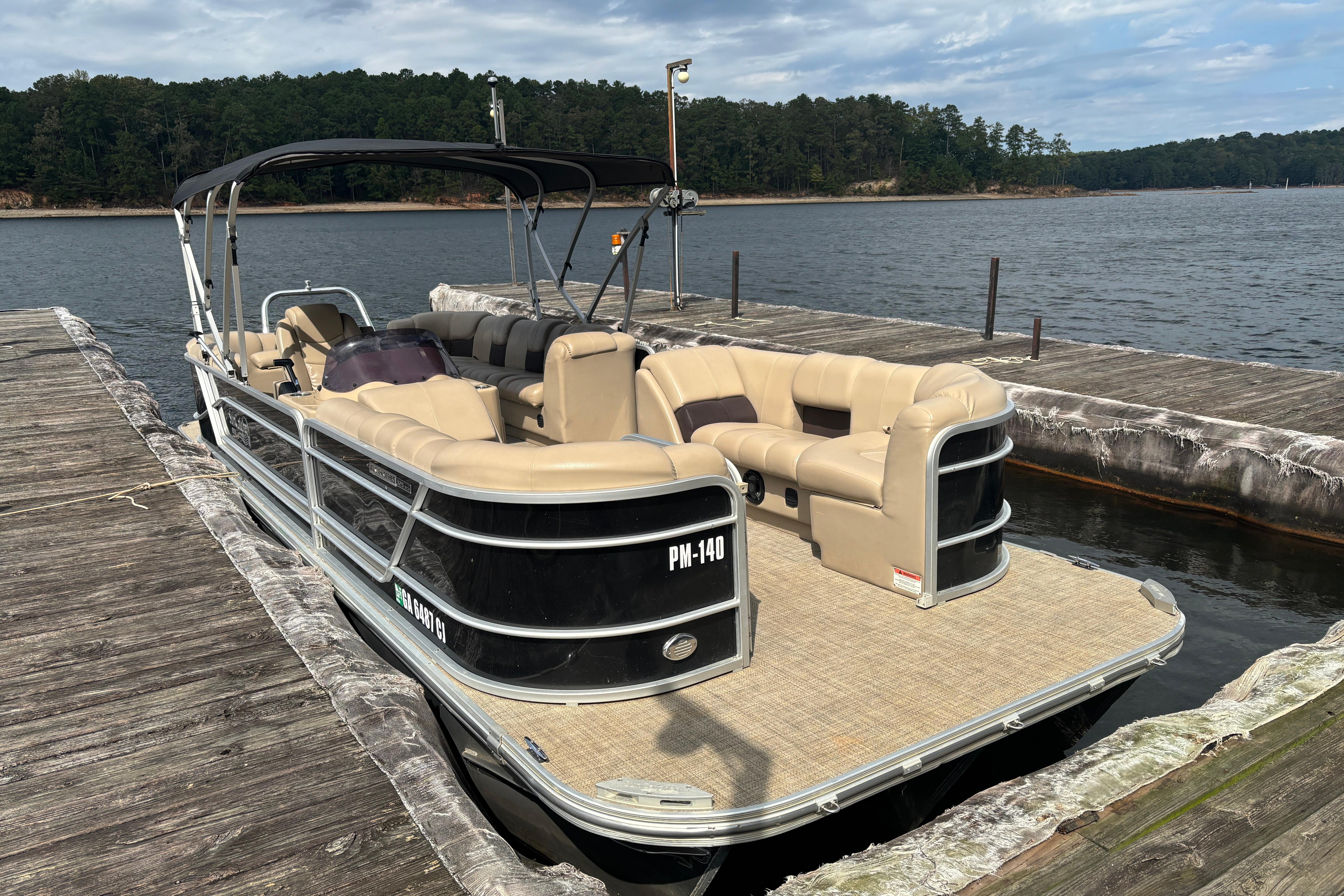 2021 SunCatcher Fusion 325RCX pontoon boat docked on a serene lake.