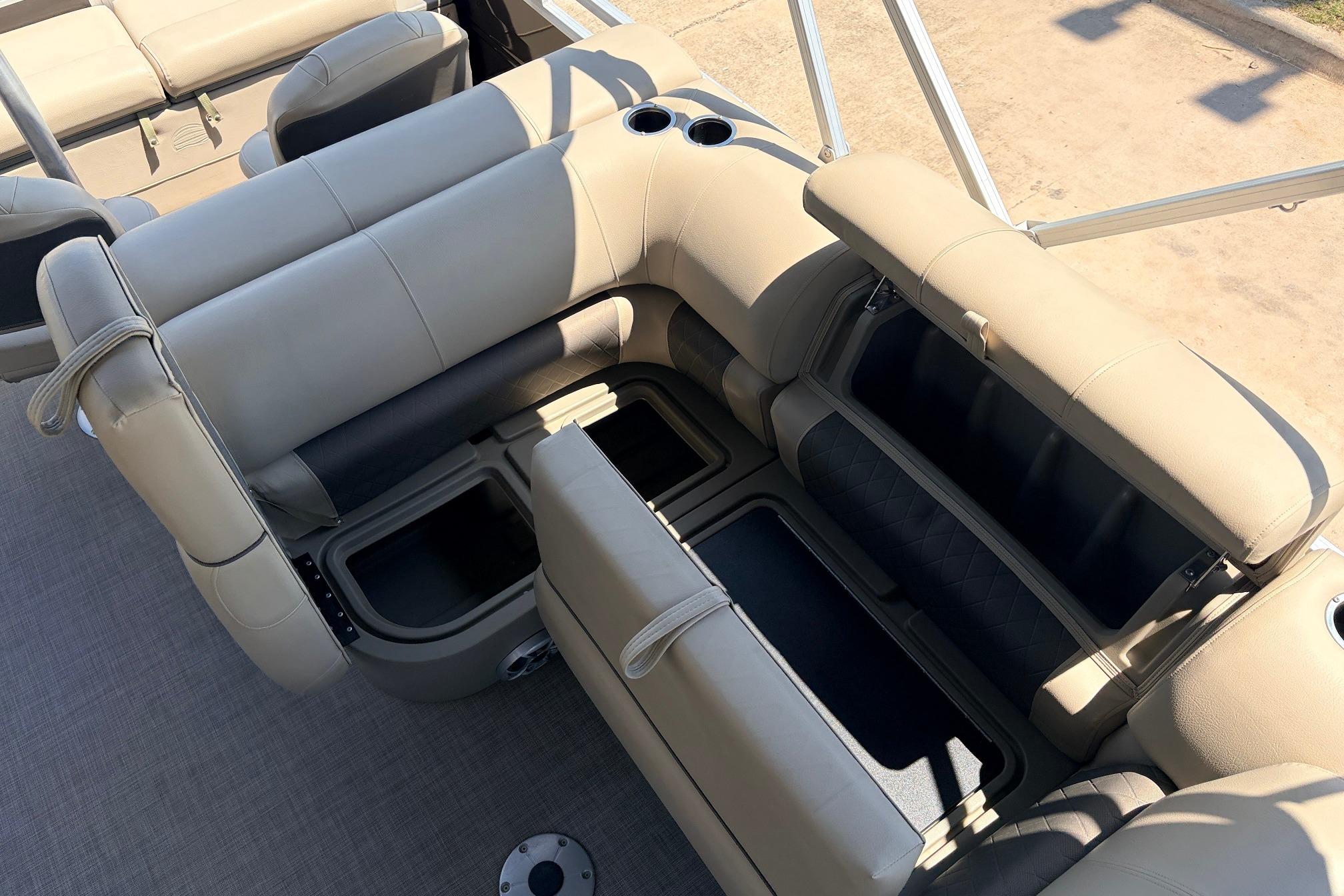 2024 Sun Tracker SportFish 22 XP3 boat interior with beige seating and storage compartments.