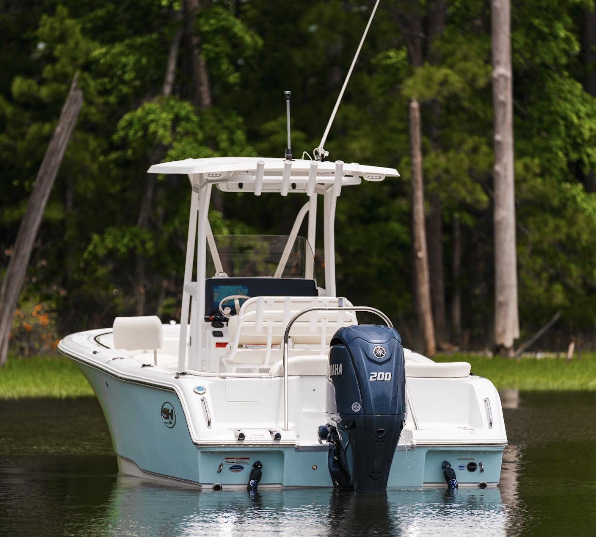 2025 Sea Hunt Ultra 229 boat with Yamaha 200 engine on a calm lake.