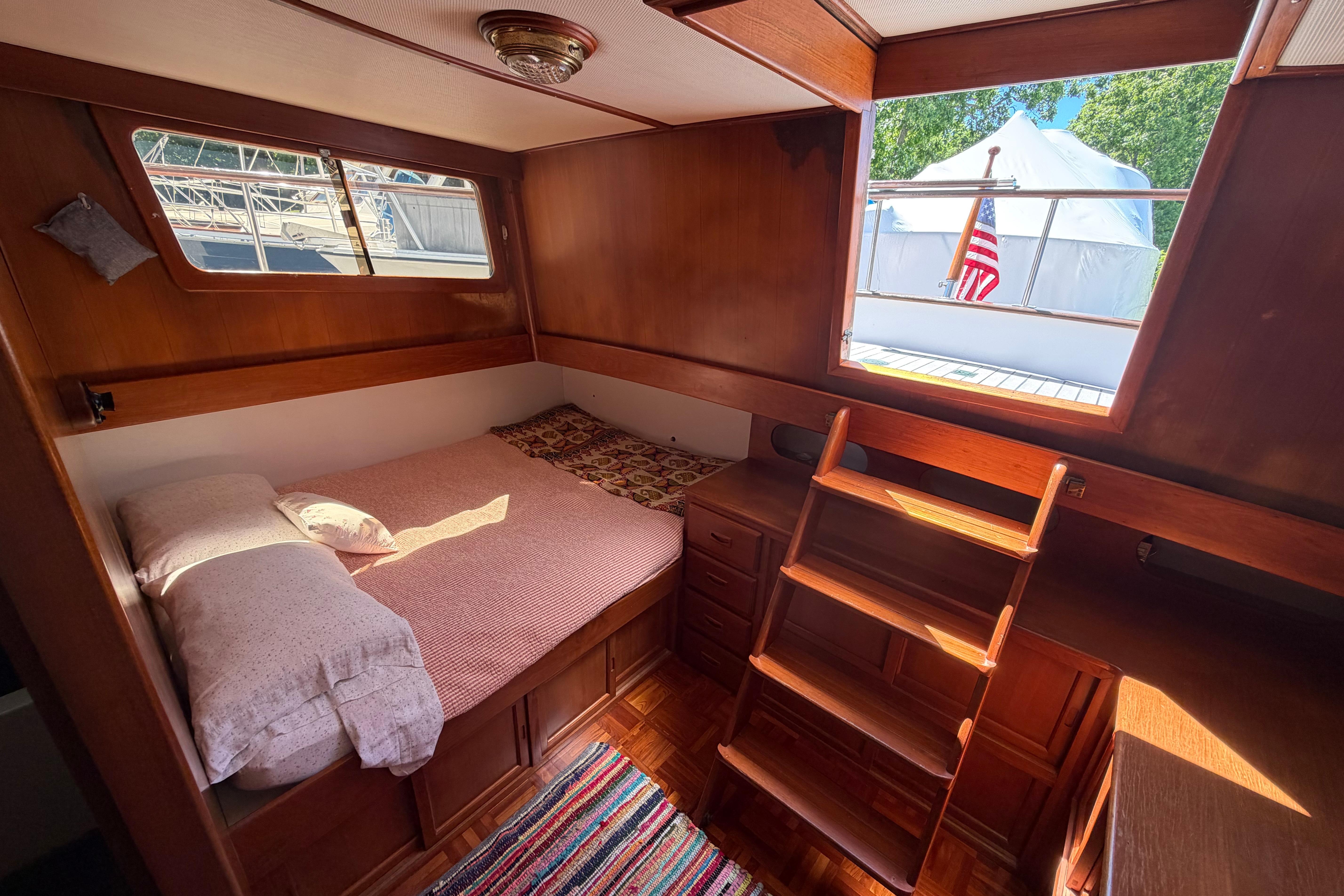 Cozy cabin interior of 1987 Marine Trader 36 yacht with wooden furnishings and natural light.