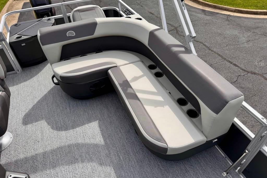 2026 Sun Tracker Bass Buggy 18 DLX pontoon boat interior with cushioned seating and cup holders.