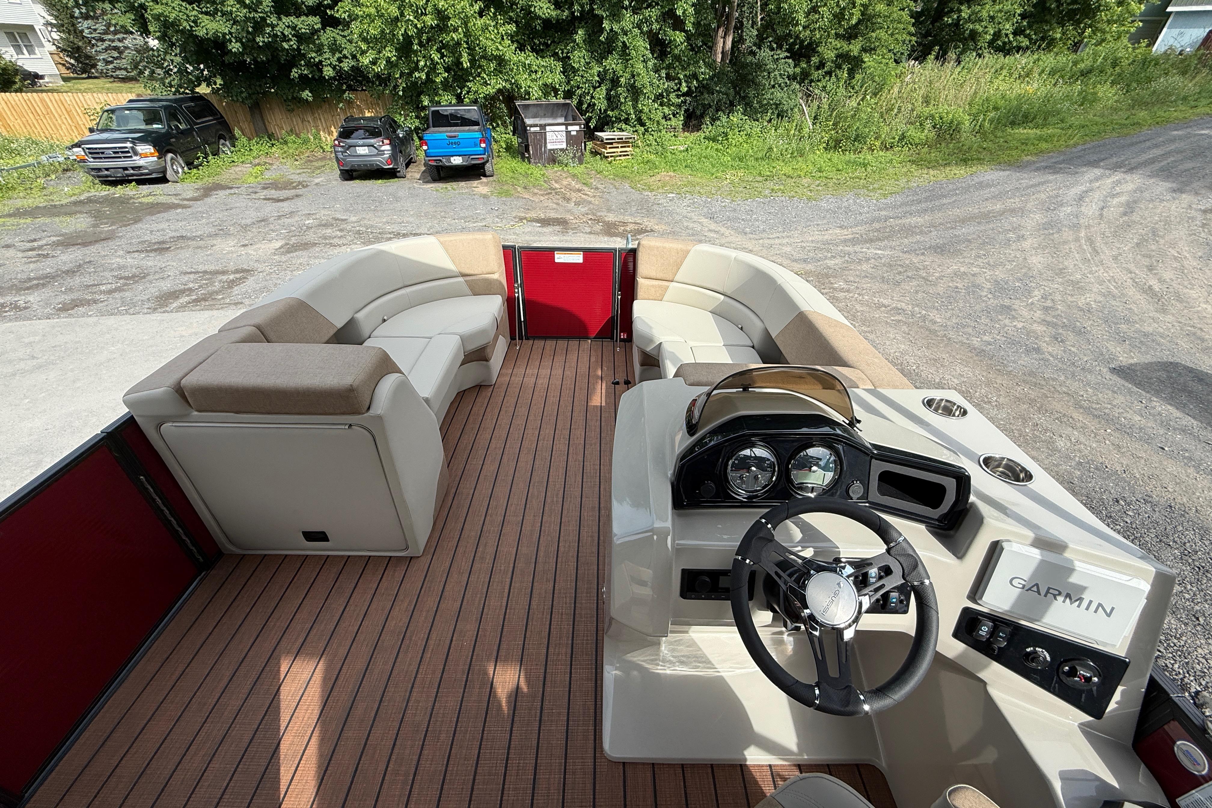Interior view of 2027 Manitou 21 Aurora LE pontoon boat with seating and steering console.