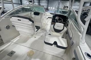 2022 Robalo R247 Dual Console boat interior with seating and steering wheel in a showroom.
