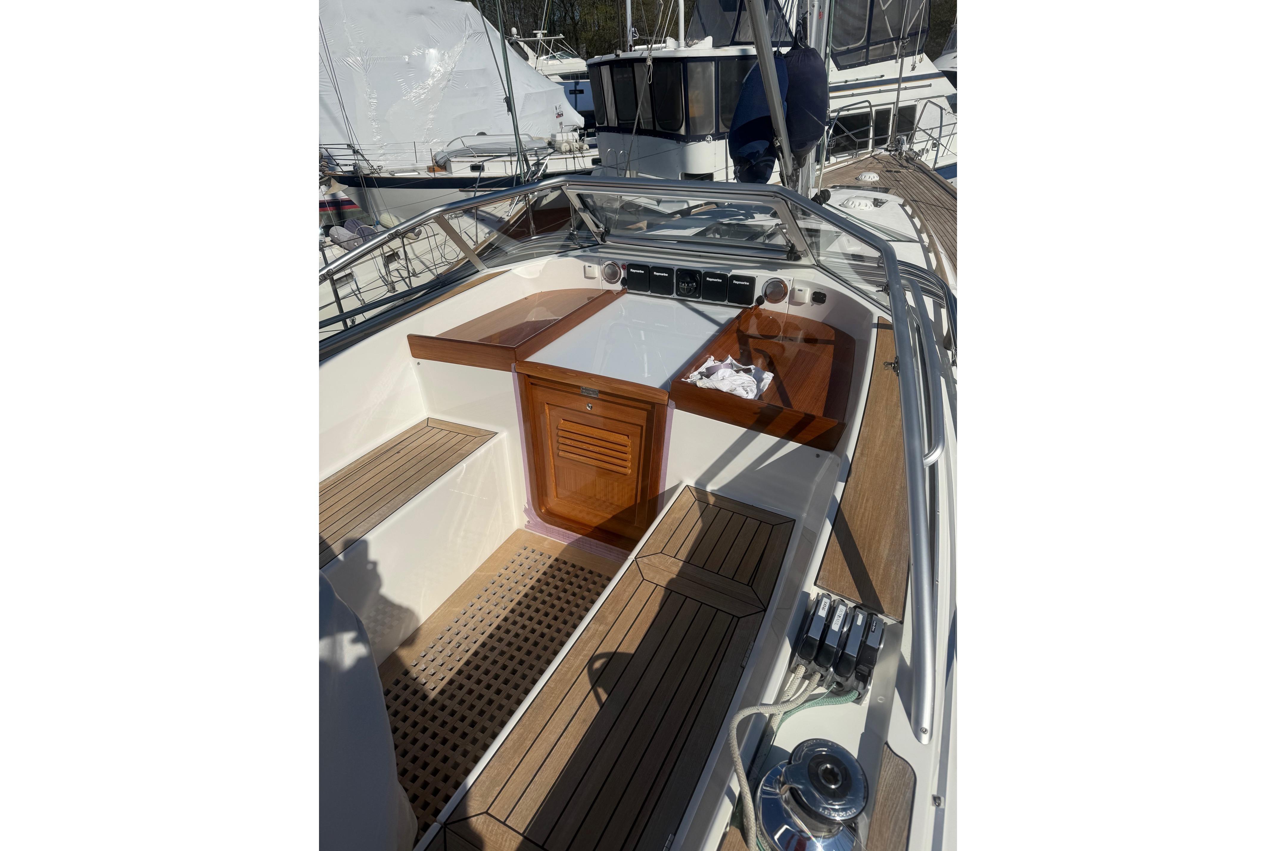 Cockpit of 2021 Hallberg-Rassy 40C sailboat with teak wood finish and modern controls.
