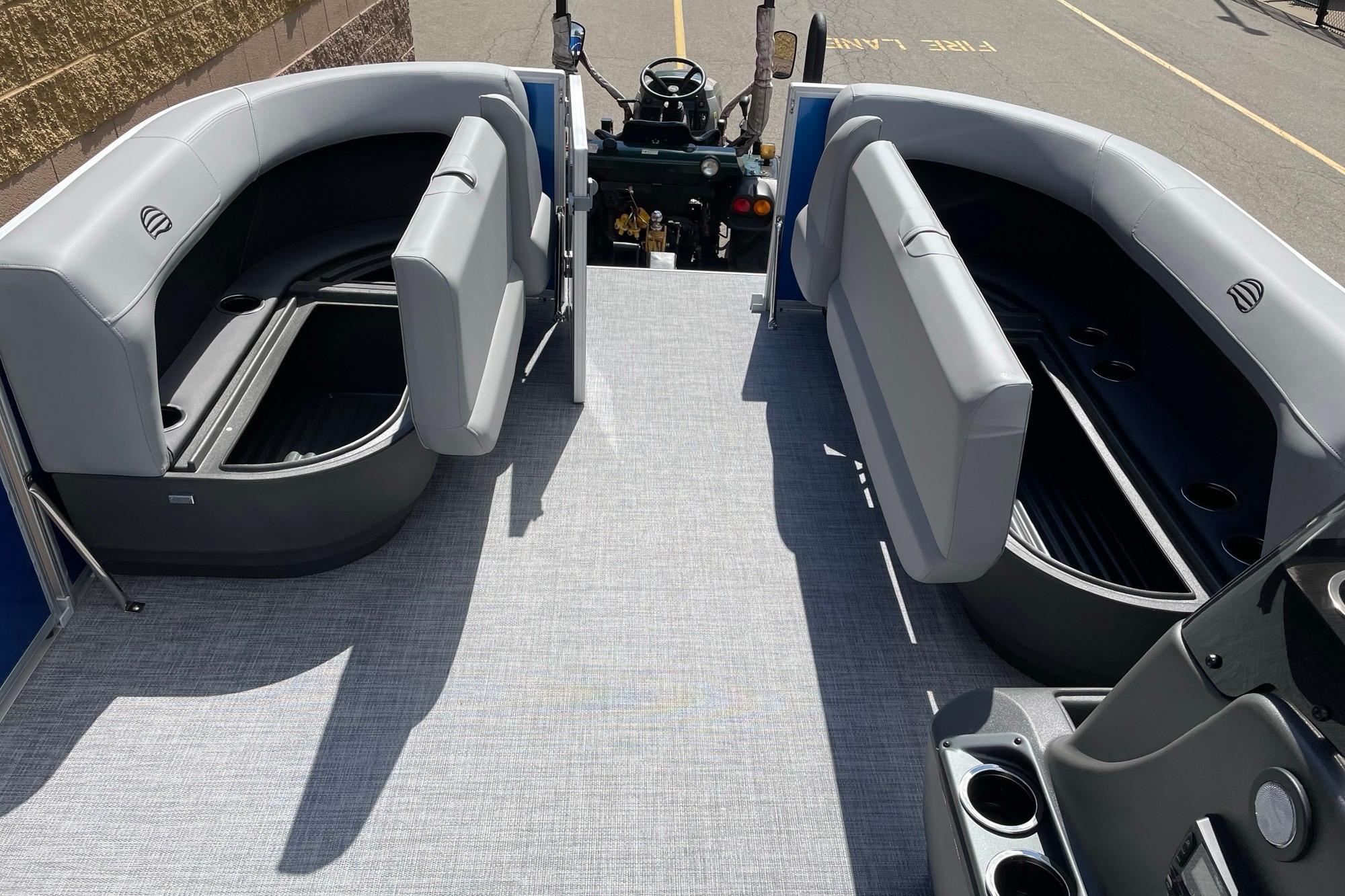 2026 Sun Tracker Party Barge 16 DLX interior with gray seating and storage compartments.