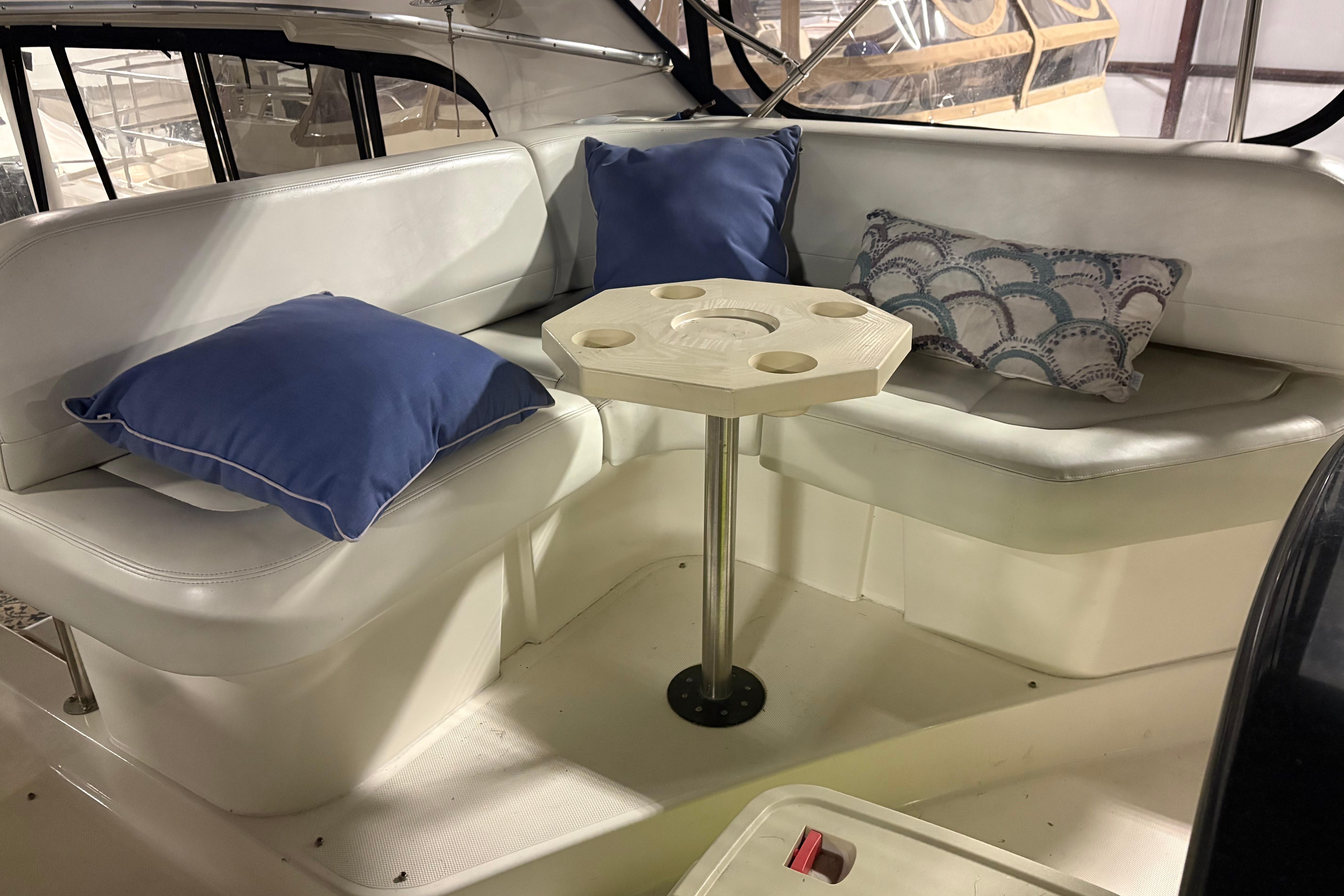 2003 Silverton 43 Motor Yacht interior with cushioned seating and decorative pillows.