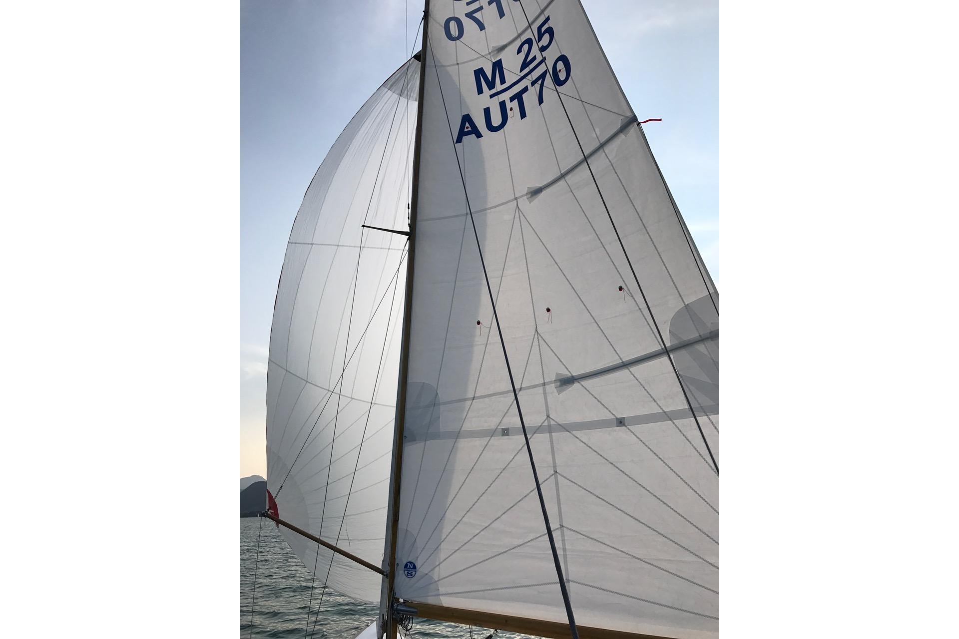 Sailing yacht Mälar 25, 1951 model, with white sails against a clear sky.
