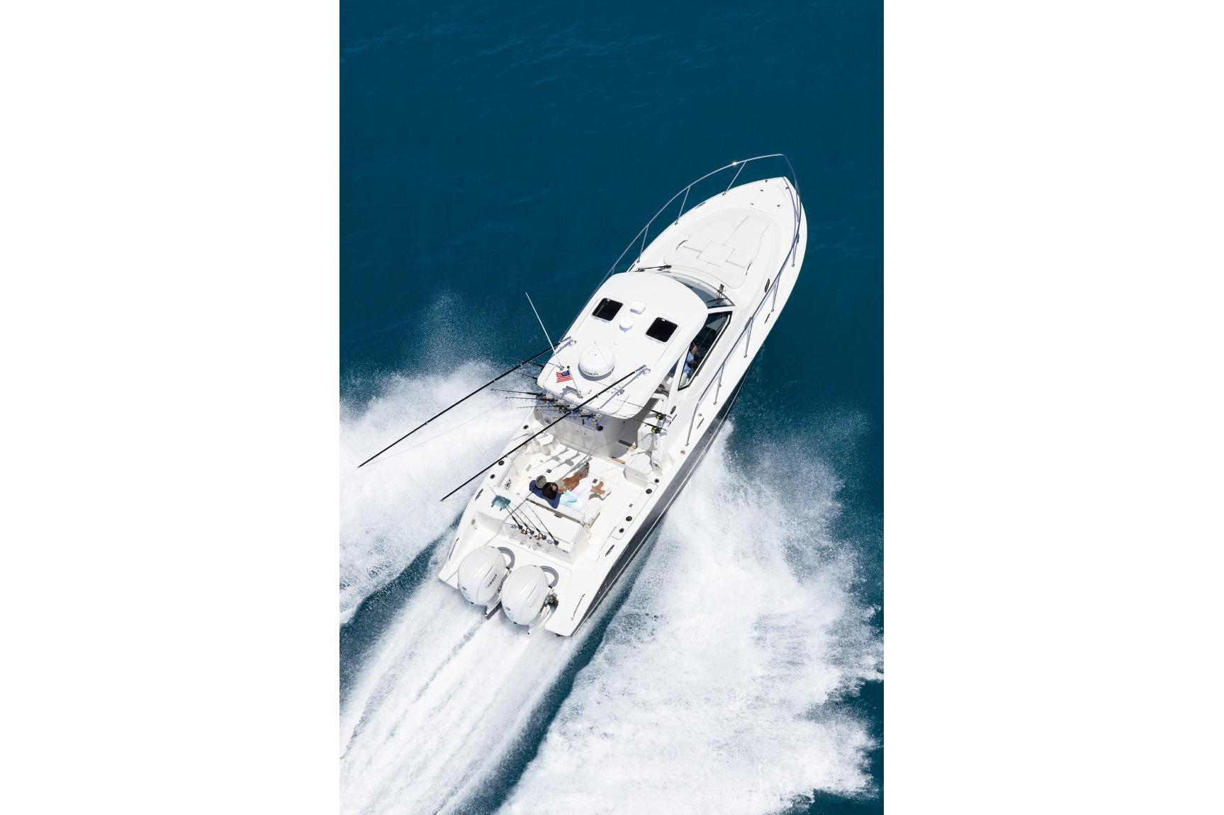 2026 Pursuit OS 325 Offshore boat cruising on open water, aerial view.