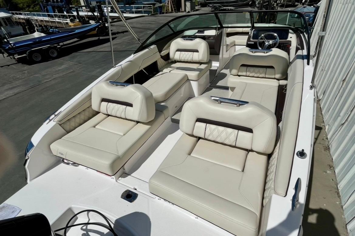 2025 Regal LX2 boat with luxurious beige seating, docked at a marina.