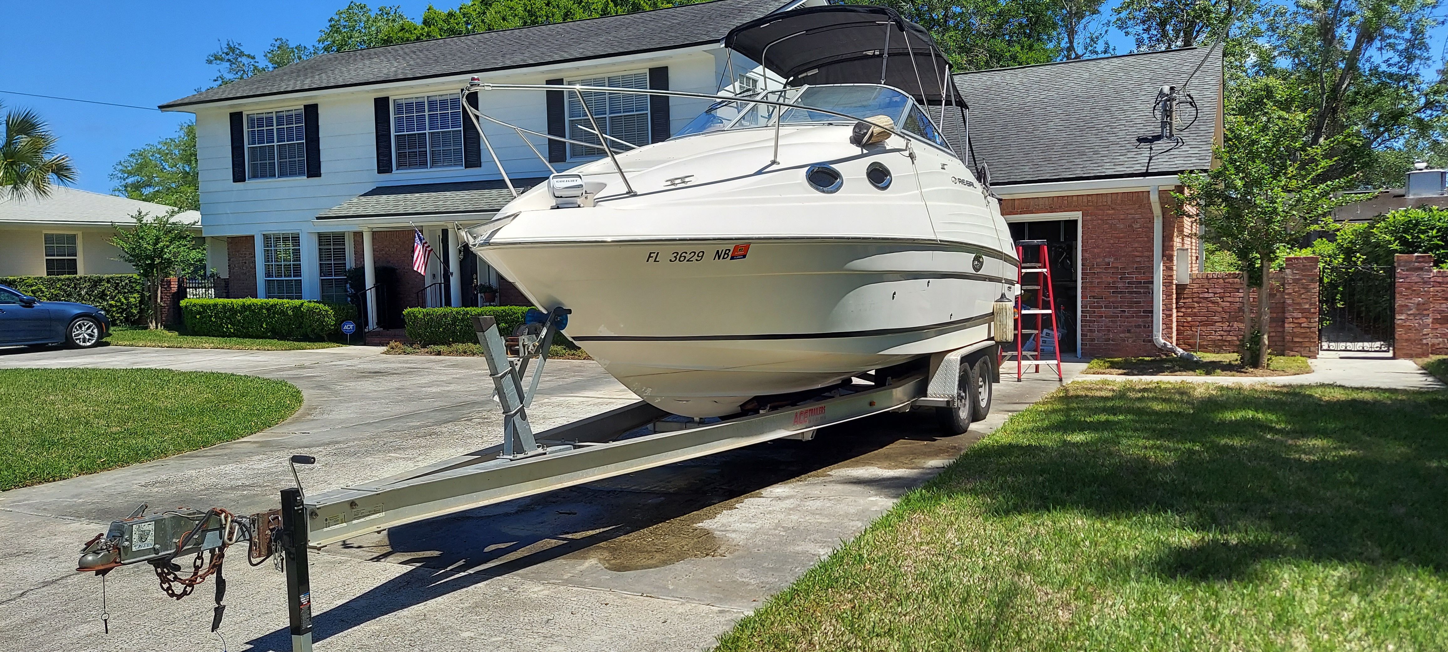 2004 Regal Commodore 2465 boat on trailer parked in driveway.