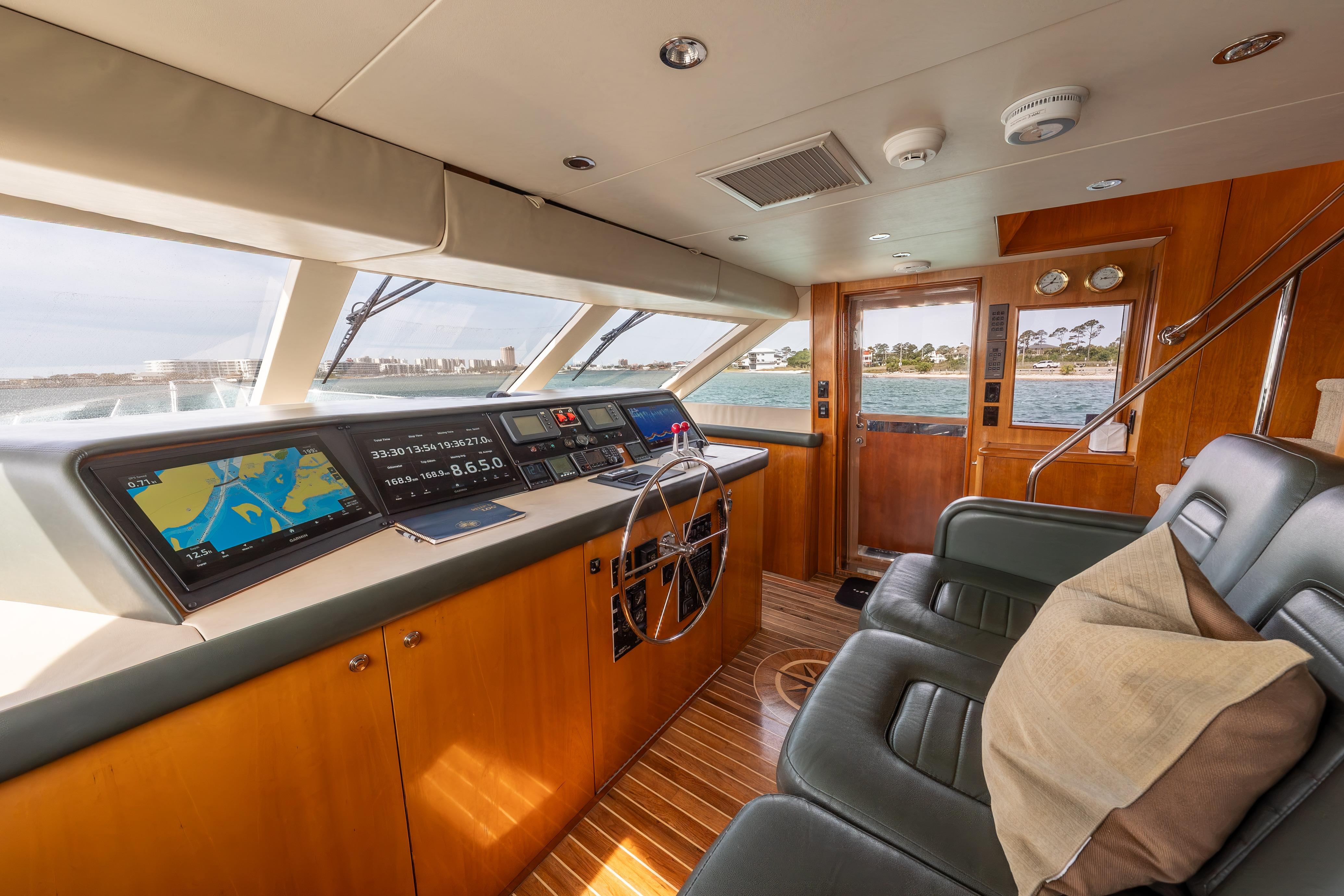 Luxurious helm of 2004 Hatteras 75 Sport Deck Motor Yacht with modern navigation systems.