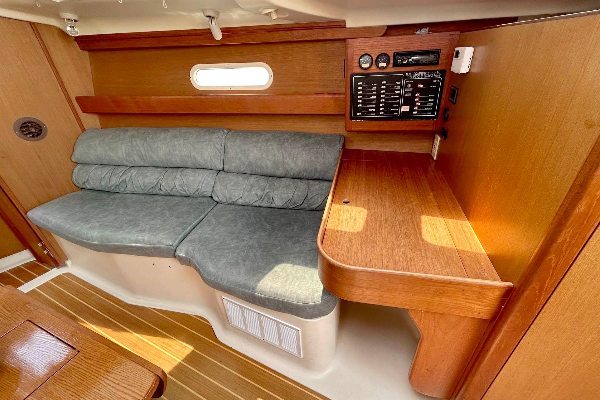 Interior of a 1998 Hunter 340 sailboat with cushioned seating and wooden cabinetry.
