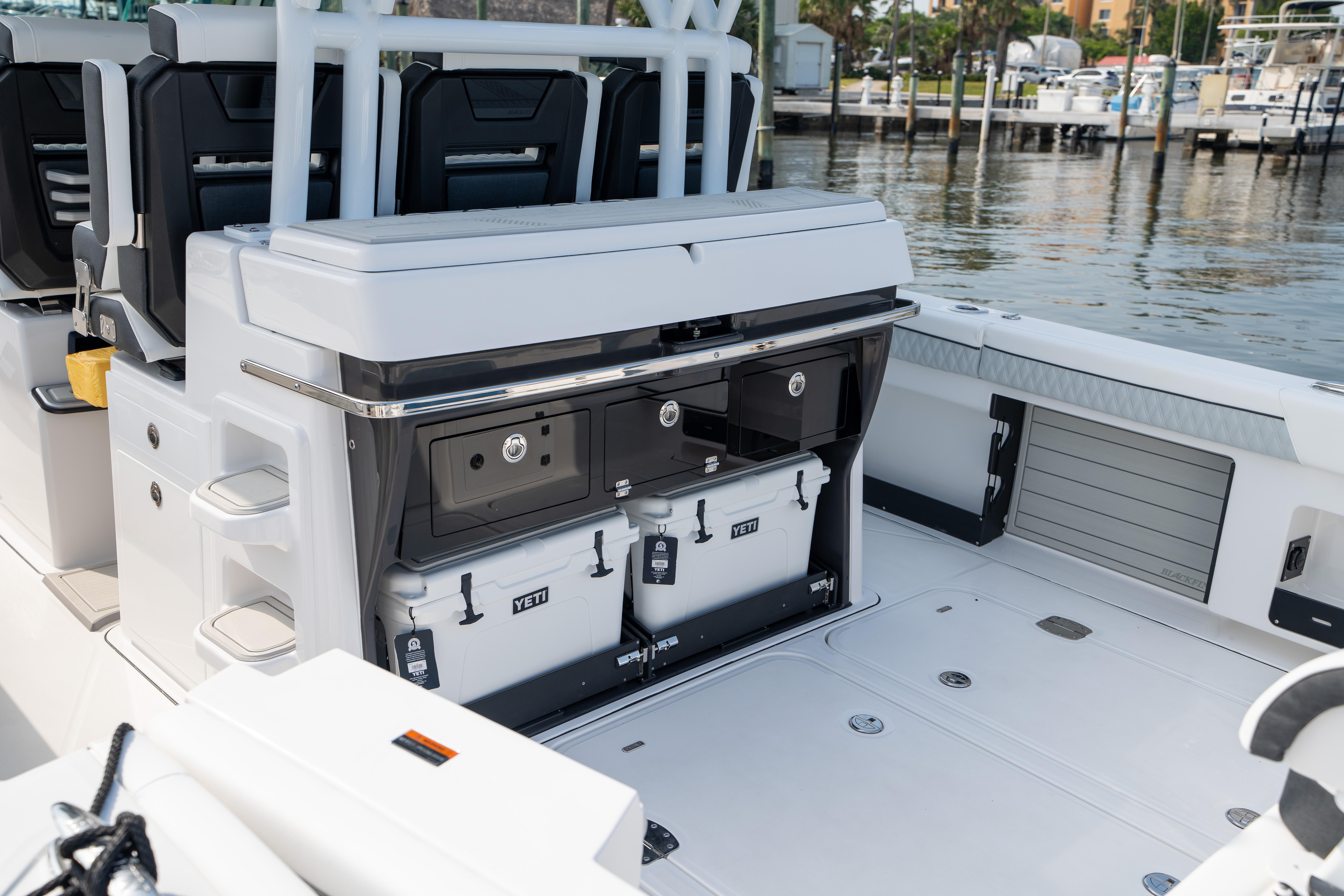 2024 Blackfin 400 CC boat interior with storage compartments and seating, docked at marina.