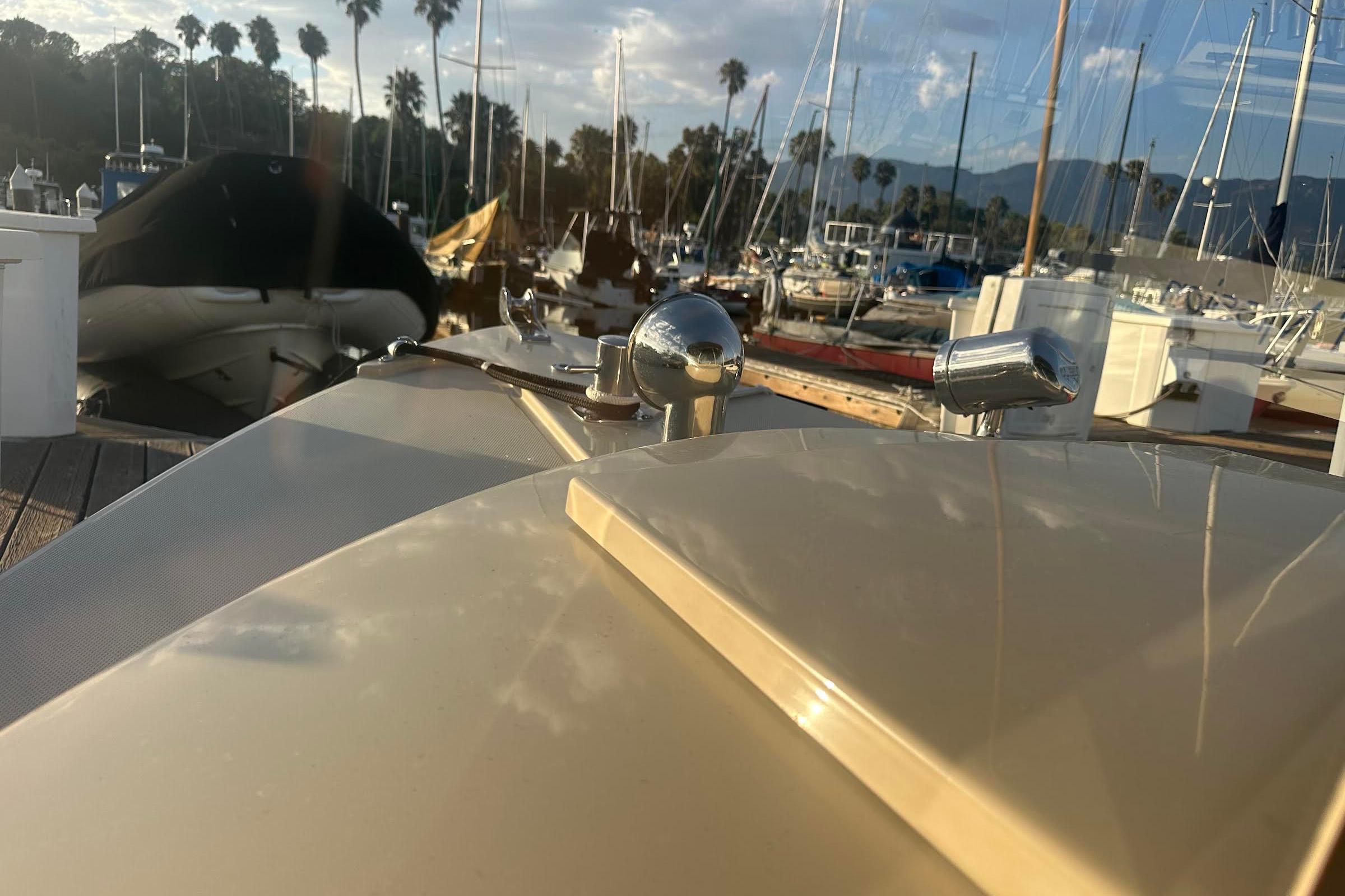2007 Duffy 22 Electric boat docked at marina with sailboats and palm trees.