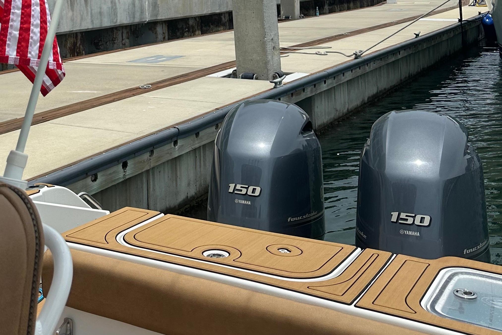 2019 Sea Hunt Gamefish 25 with twin Yamaha 150 engines docked at marina.