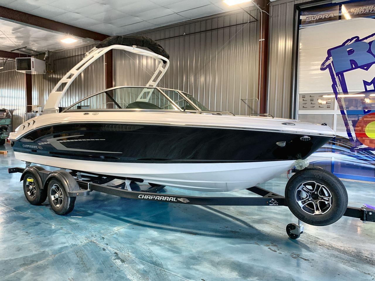 2025 Chaparral 21 SSi boat on trailer in showroom setting.