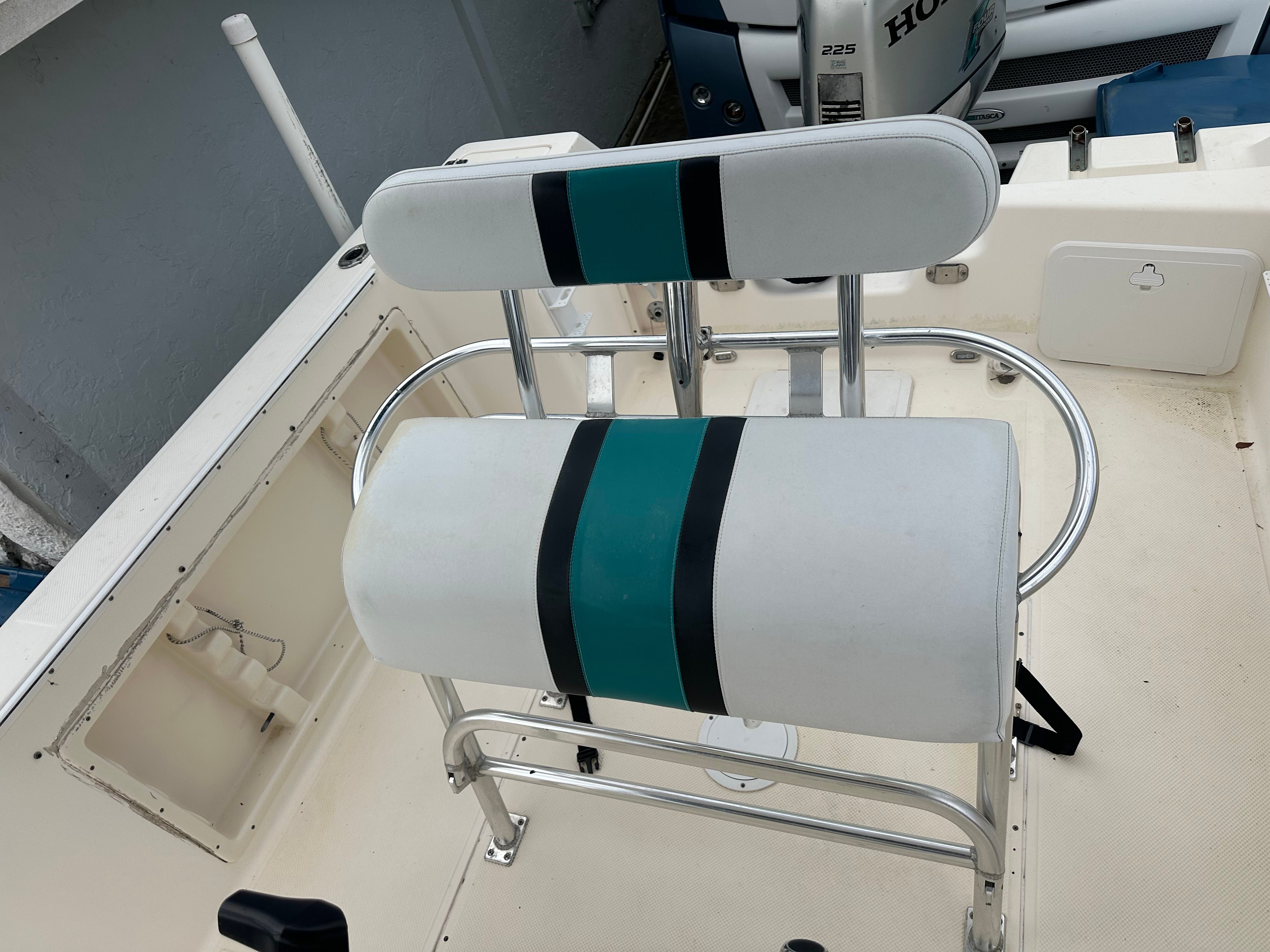 A white boat seat with blue and black stripes on a Key West Blue Water 225cc.