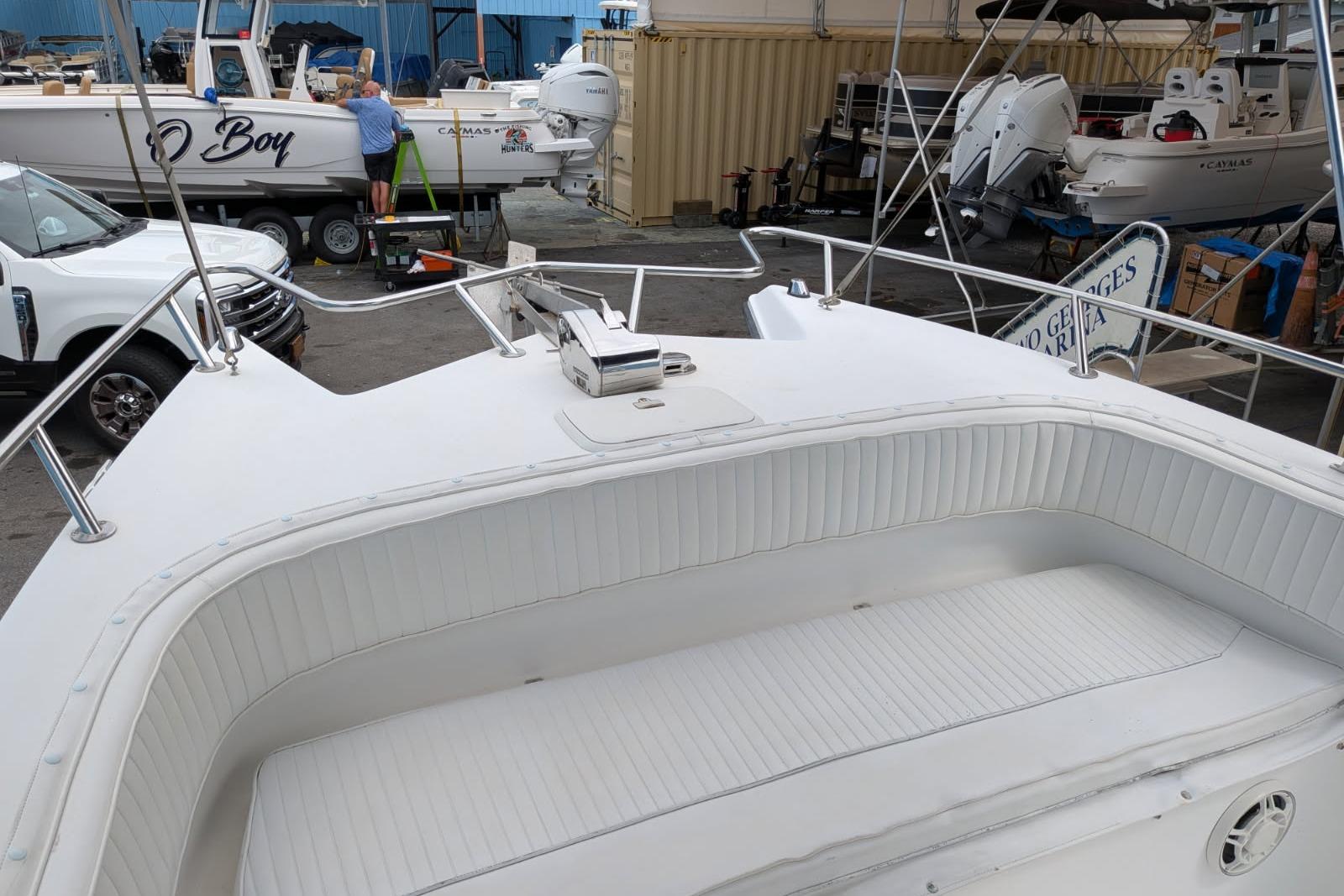 2002 Pro Sports 2200 CC ProKat boat with white seating, docked at marina.