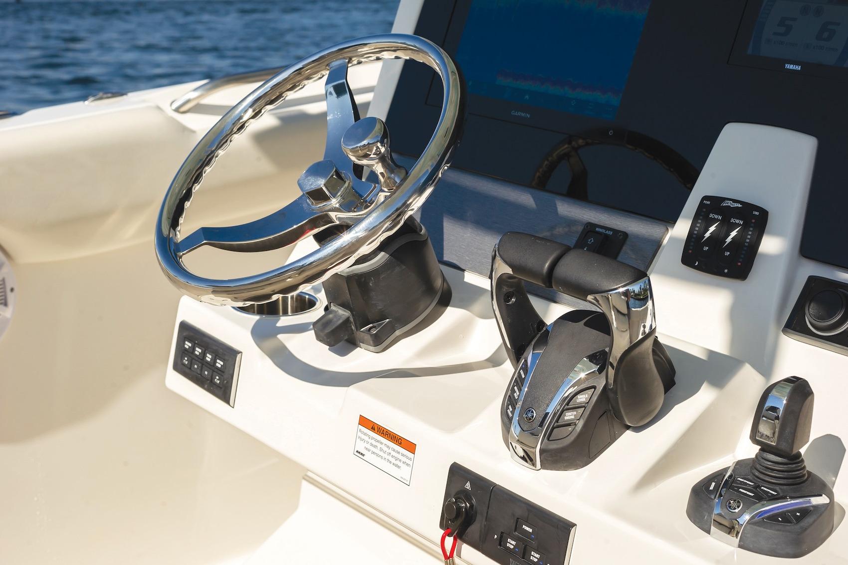 Steering console of 2027 Sailfish 312 CC boat with modern controls and chrome wheel.