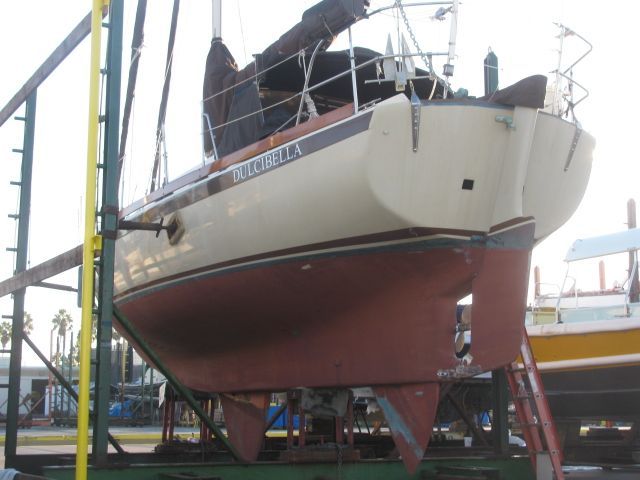 A sailboat named Dulcibella is on a dry dock.