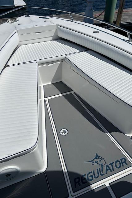 2003 Regulator 26 Forward Seating boat with white cushioned seats and logo.