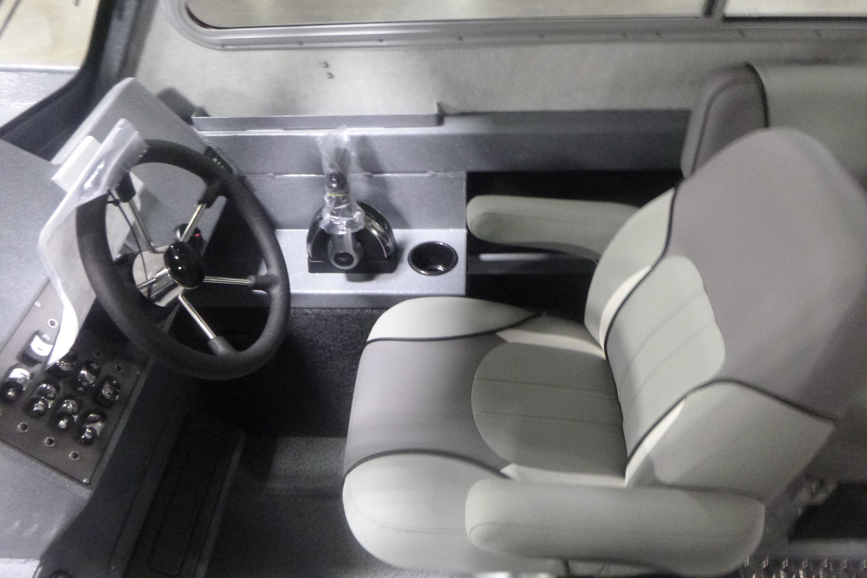 Interior of 2026 KingFisher 2425 Escape HT boat with steering wheel and captain's chair.