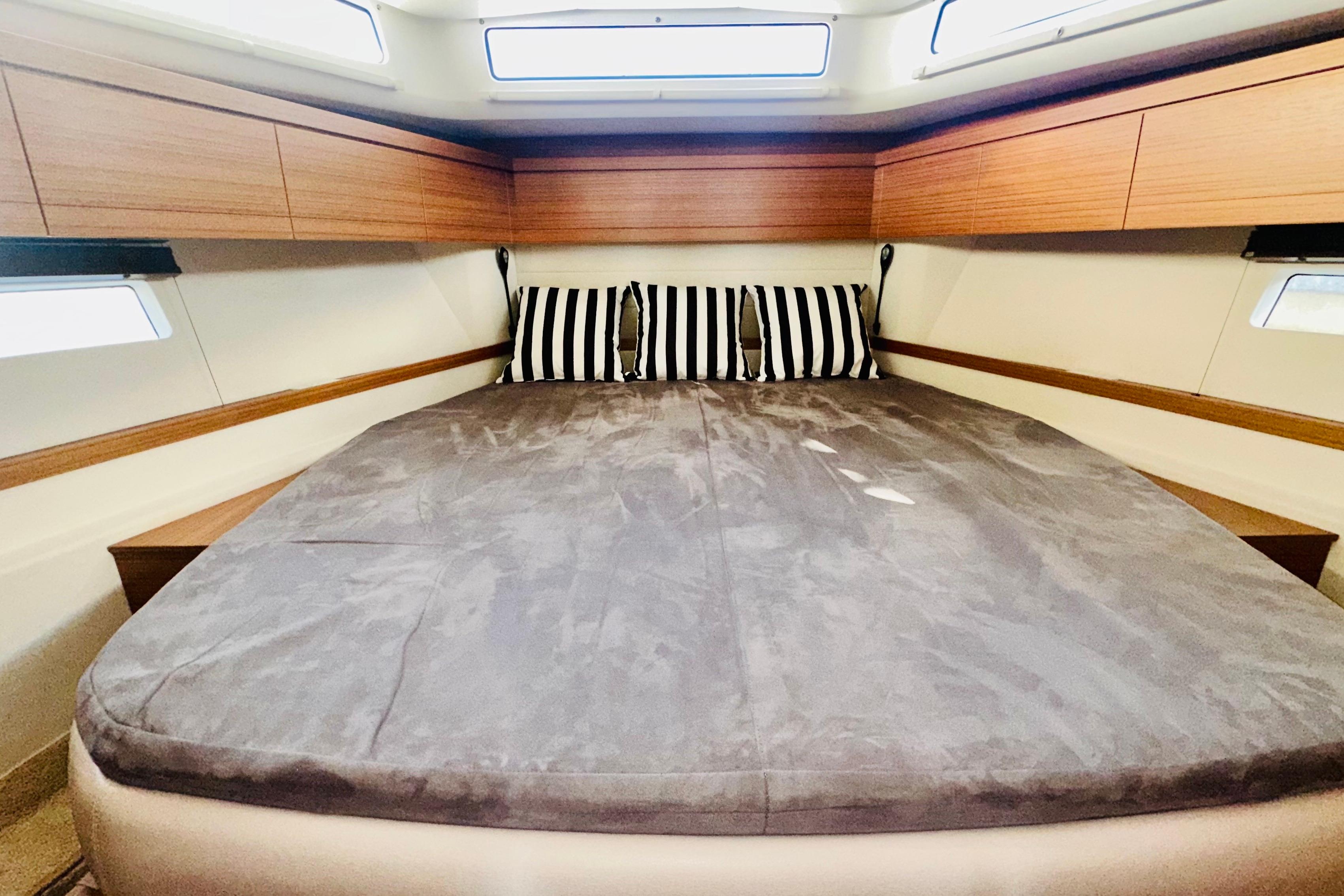Luxurious cabin interior of 2021 Greenline 39 Hybrid yacht with striped pillows.