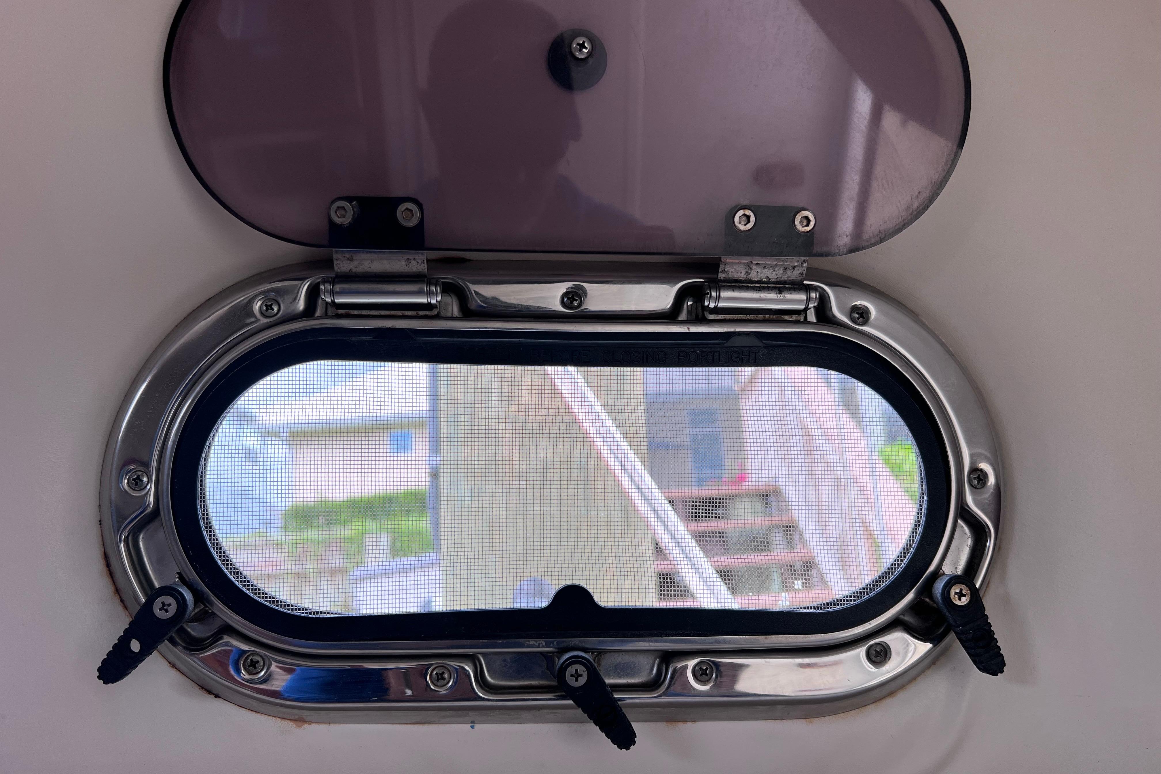 Porthole view from a 2005 Pursuit 3070 Offshore boat, showcasing exterior scenery.