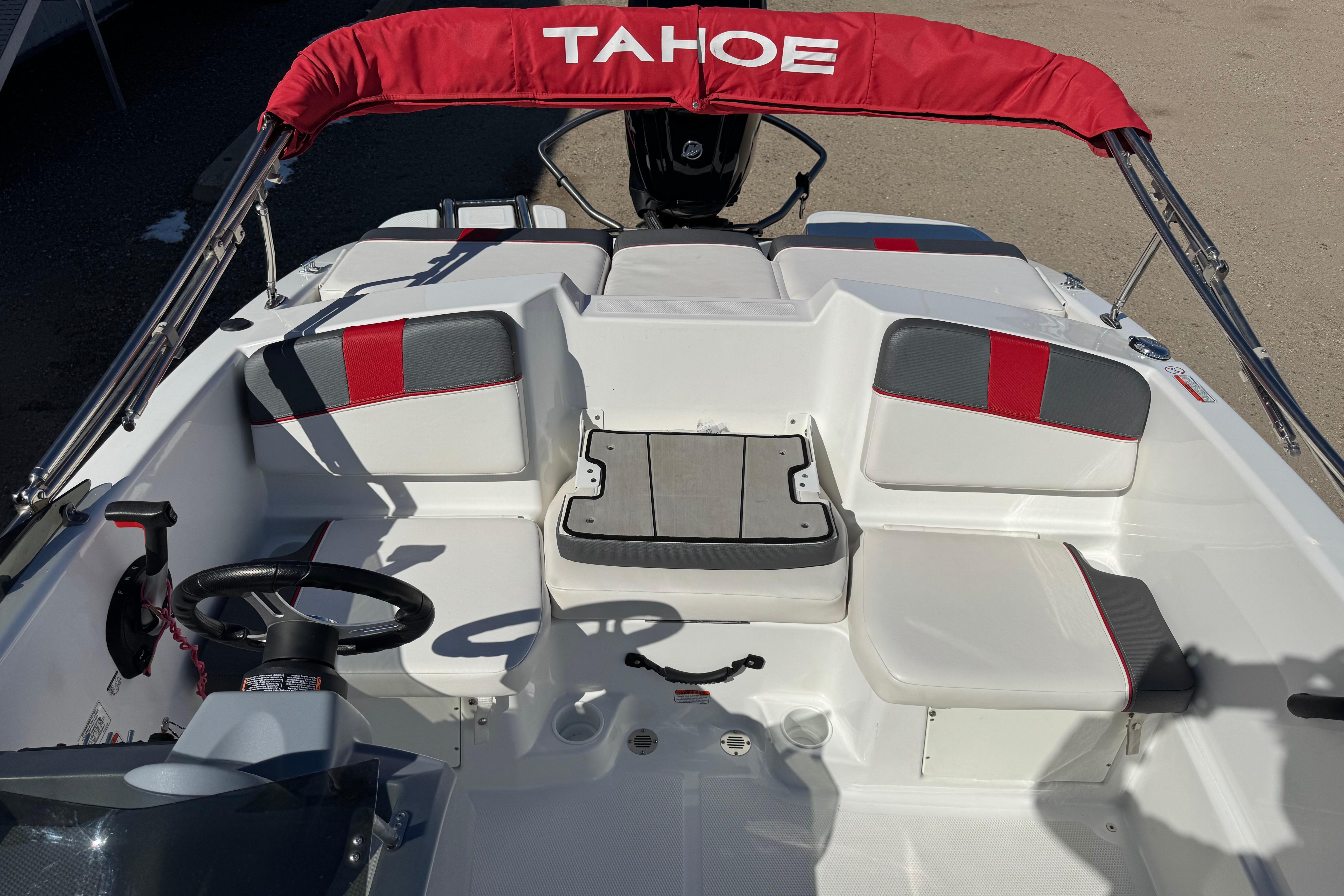 2021 Tahoe T16 boat interior with red and gray seating, steering wheel, and canopy.