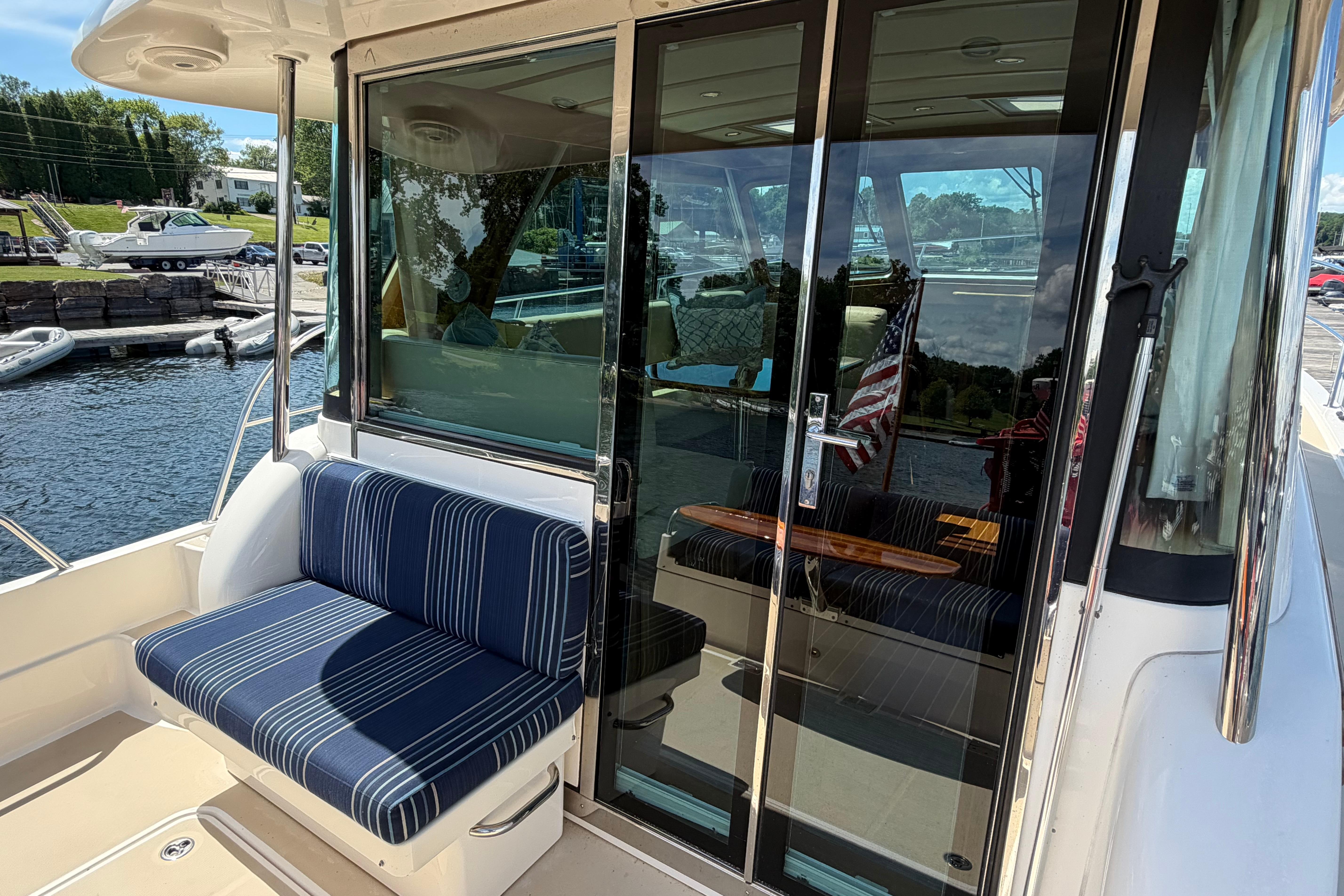2015 Sabre 38 Salon Express yacht with striped seating and glass doors at a marina.