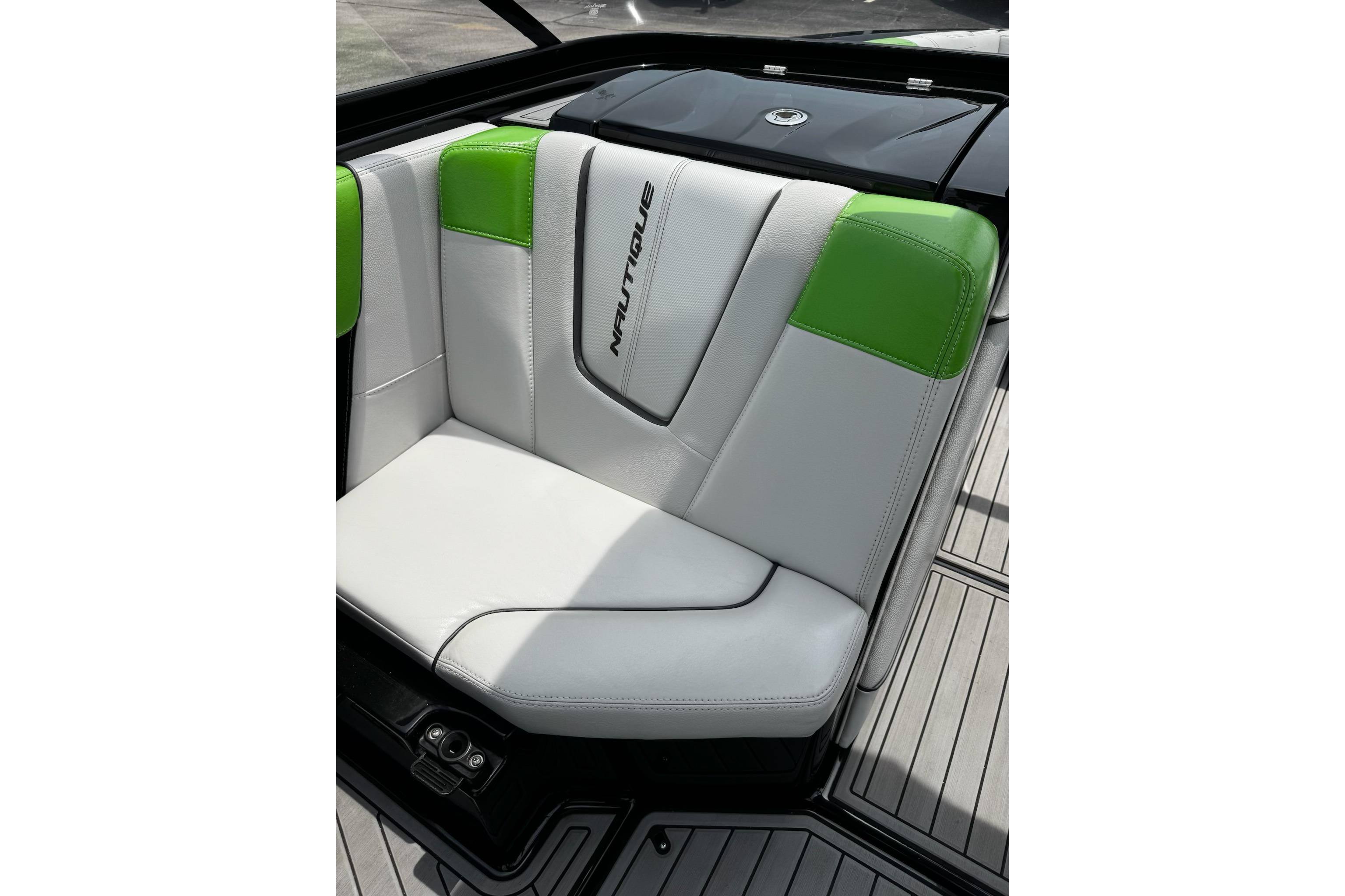 2014 Nautique Super Air Nautique G21 boat seat with green and white upholstery.